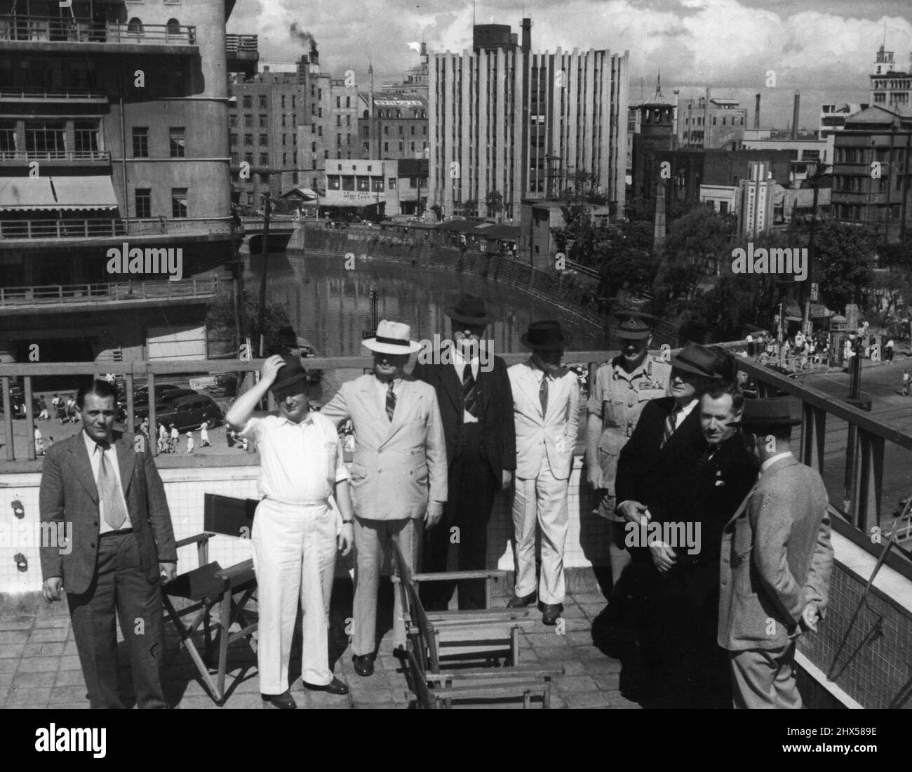 Auf dem Dach des Union Jack Clubs in Tokio, des Clubs für andere Ränge des BCOF, mit Blick auf Tokio im Hintergrund. Von links nach rechts: Herr Fred Johnson. Verbindungsoffizier mit der Partei; Senator R.J. Murray; Senator J. A. Cooke; Herr E.H. Russeli; Colonel R.A. Ryan, C.M.G., D.S.O. ; Lieut-General H.C.H. Robertson, C-in-C BCOF; Herr J. Francis; Herr L.C. Haylen und Mr. C.W. Davidson. Derzeit besucht eine Delegation des australischen Parlaments aus allen Parteien Japan. Sie kamen in der Lundroon an und wurden von Iwakuni noch am selben Tag nach Tokio geflogen, rechtzeitig zum Mittagessen mit dem Obersten Befehlshaber, General der Armee Douglas Mac Stockfoto