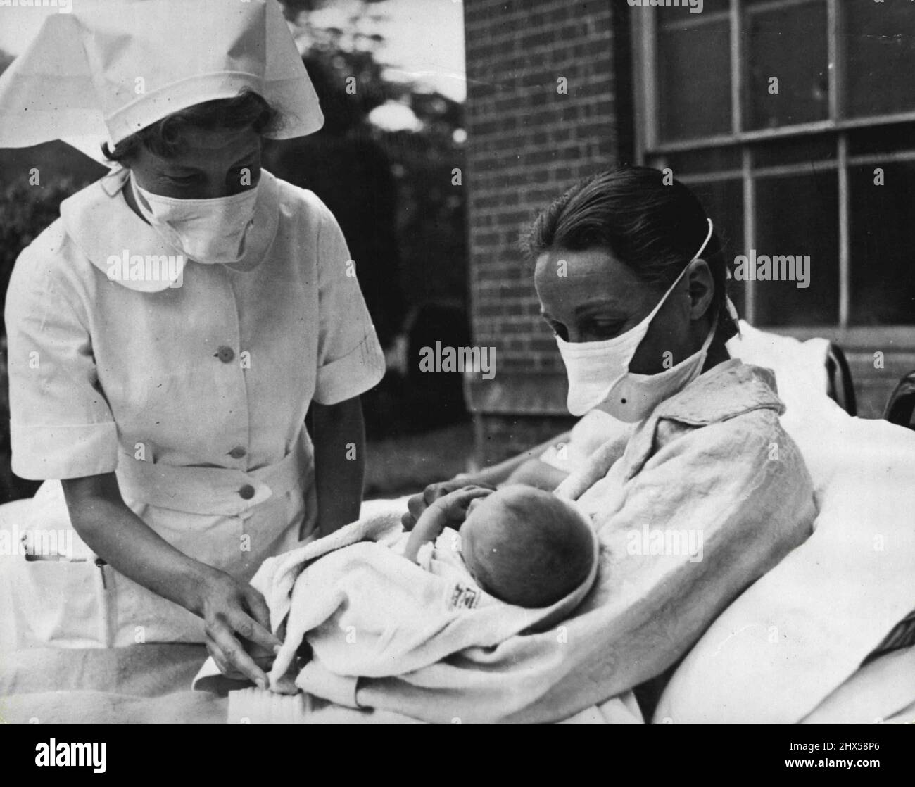 Mansion wird zum Mutterhaus Mutter und Krankenschwestern tragen eine Schutzmaske, wenn das Baby in der frühen Phase behandelt wird. Die ganz jungen Menschen sind leicht Beute von Keimen. 01. September 1951. Stockfoto