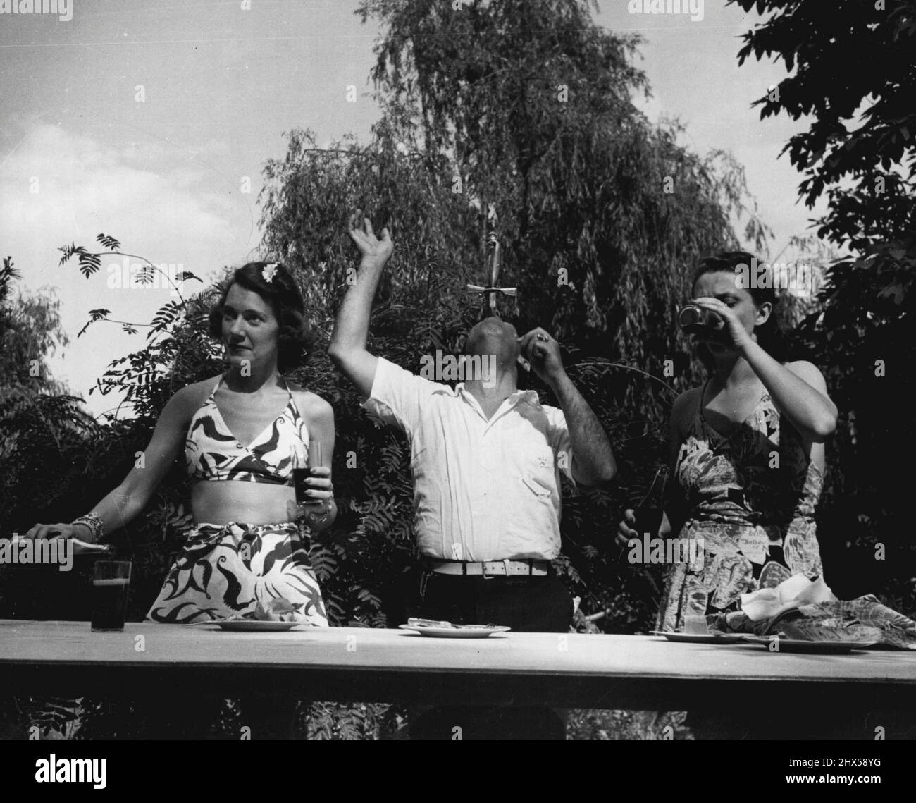 Sword Swallower Ajax konnte diese beiden Mädchen zur Mittagszeit nicht stören. Alle Gäste von Ripley ziehen am Nachmittag ein besonderes „Believe-IT-or-Not“-Kostüm an. 5. Oktober 1940. (Foto von John Phillips). Stockfoto