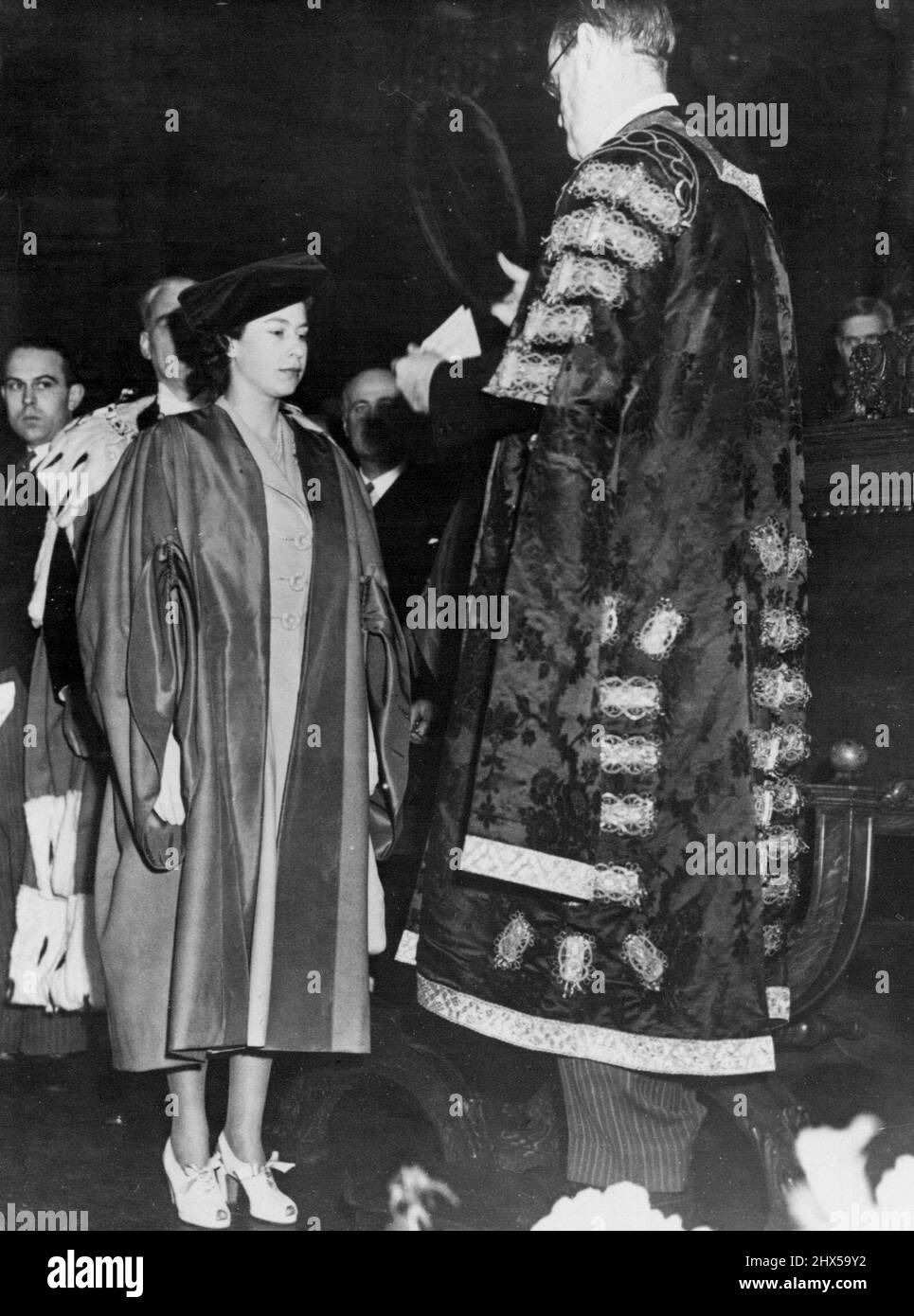 Abschluss für den Besuch der Princess Edinburgh University -- Prinzessin Elizabeth hat den Grad eines Doktor der Gesetze, der ihr vom Kanzler, der Marquess von Linlithgow, in der M'Ewan Hall der Edinburgh University verliehen wurde. Prinzessin Elizabeth besuchte gestern (Mi) in Begleitung des Herzogs von Edinburgh die Universität Edinburgh, wo die Prinzessin den Ehrendoktortitel der Rechtswissenschaften erhielt. Mit einem scharlachroten Kleid und einer schwarzen akademischen Mütze über einem taubengrauen, maßgeschneiderten Mantel und Kleid wurde die Prinzessin begeistert aufgenommen, als sie nach der Zeremonie auf der Plattform erschien, um ihre Rede zu halten. 03. März 194 Stockfoto