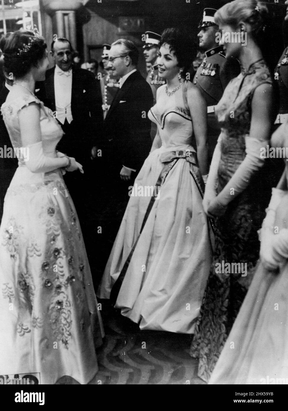 Die Königin chattet mit Gina -- die Königin chattet mit Italiens glamouröser Gina Lollobrigida, während sie die Stars am Odeon, Leicester Square, London, trifft, wo ihre Majestät und der Herzog von Edinburgh an der königlichen Filmvorstellung von „To Catch a Thief“ teilnahmen. Neben Gina befinden sich Virginia McKenna und David Kossof. 31. Oktober 1955. (Foto von Reuterphoto). Stockfoto