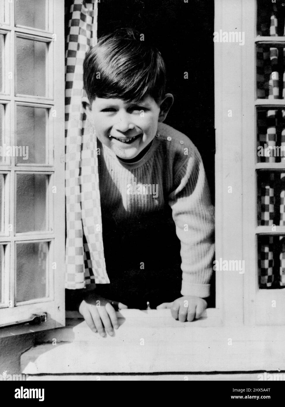Glückliche Prinzen -- Dieses glückliche Bild von Prinz Charles wurde von der königlichen Fotografin Lisa aufgenommen, als der junge Prinz aus dem Küchenfenster des walisischen Hauses in der Royal Lodge Windsor schaute. 22. April 1954. (Foto von Paul Popper Ltd.). Stockfoto