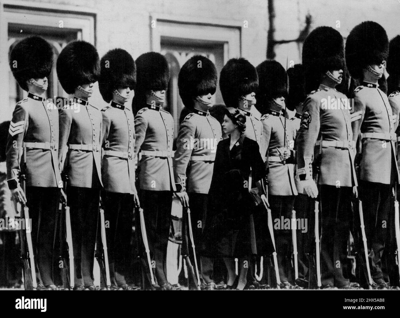 Königin Elizabeth unter den Giganten -- Königin Elizabeth, die vor der Präsentation die Soverign's Company der Grenadier Guards inspiziert. ***** Das Unternehmen ist eines der besten ***** Männer in der gesamten britischen Armee. Im Schloss Windsor überreichte die Königin der Königlichen Kompanie die Farbe und den königlichen Standard des Regiments der Königlichen Kompanie der 1. Grenadier und der Königliche Standard ist eine Besonderheit der Grenadier Guards und hat kein Gegenstück in einem anderen Infanterieregiment. Der Brauch wurde von König Karl II. Im Jahr 1661 begonnen und ist seitdem von fast jedem Soverign verfolgt worden Stockfoto