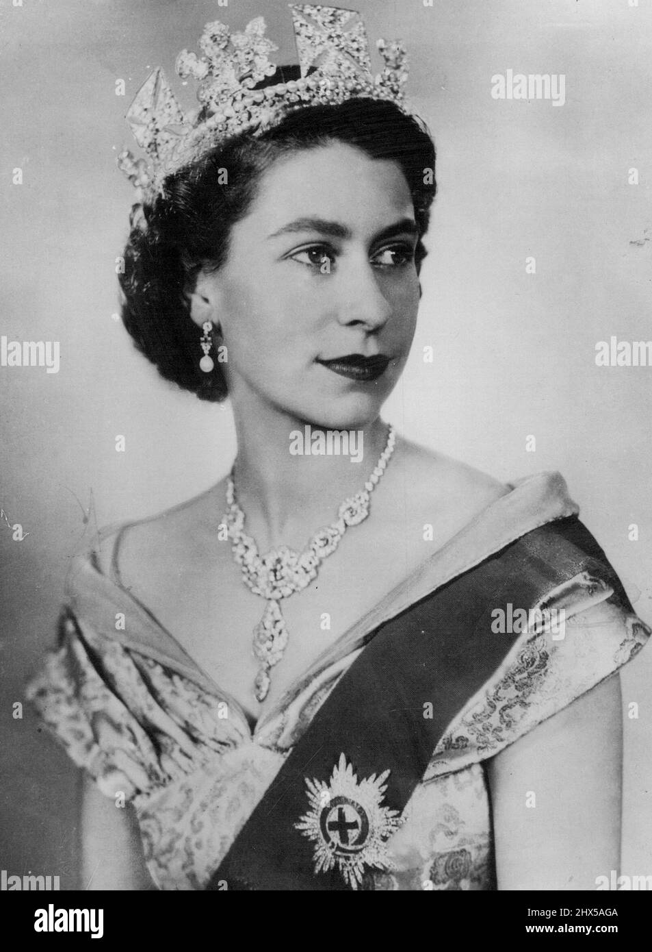 Das erste Porträt der Königin seit ihrer Aufnahme in der ersten formalen Porträtstudie, die seit ihrer Thronbesteigung aufgenommen wurde, ist Ihre Majestät Königin Elisabeth II. In einem Kleid aus Elfenbeinbrokat mit Gold- und Türkisfaden und einem Ausschnitt aus schwarzem Samt zu sehen. Sie trägt die Schärpe und den Stern des Strumpfordens, die Halskette, die ihr als Hochzeitsgeschenk vom Nizam von Hyderabad geschenkt wurde, und einen Ring aus Diamanten und Perlen. 8. Juli 1952. Stockfoto
