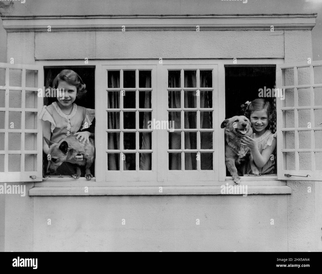 Royal Lodge Windsor. Juni 1936. - Königin Elizabeth & Prinzessin Margaret in Windsor. Modewechsel, auch in den königlichen Fotografien. Verträge, die dies 1936 gemacht hat, und eines der ersten „Schnaps“ der königlichen Familie, aufgenommen von Mrs. Sheridan, mit dem natürlichen, unbestellten Bild von Prinz Andrew, das letzten Monat gemacht wurde. Die königliche Präferenz für Corgis bleibt unverändert. 15. Juni 1953. (Foto von Camera Press Ltd.). Stockfoto