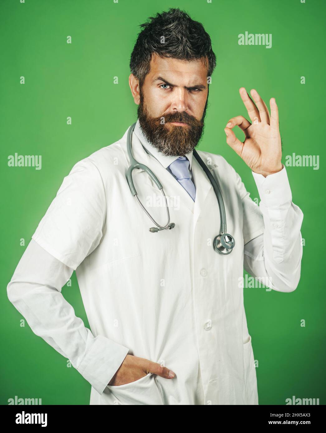 Arzt mit Stethoskop am Hals in weißem medizinischen Gewand, mit guter Geste. Medizin und Gesundheitswesen. Stockfoto