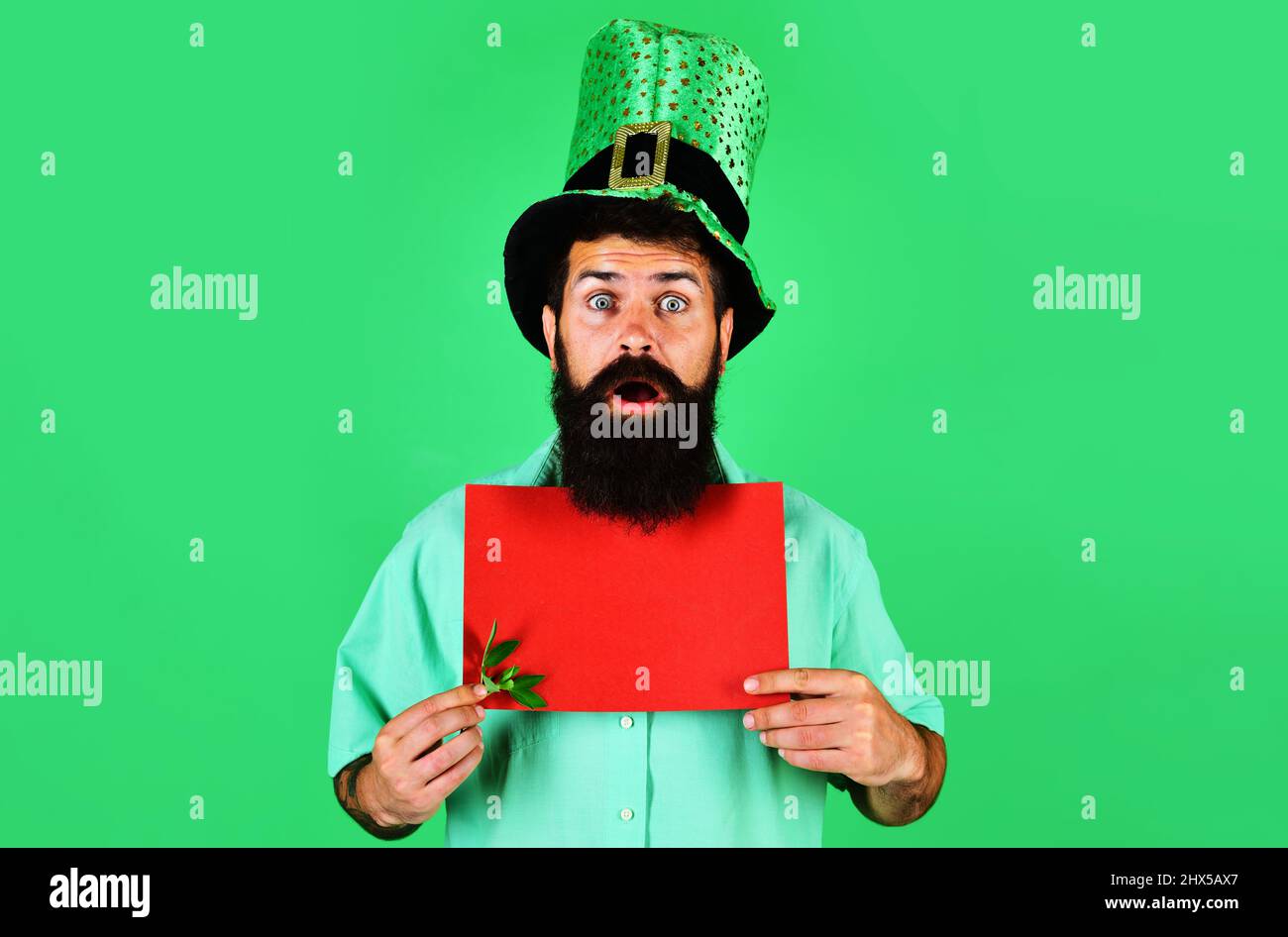 Patricks Day Feier. Überrascht Bartender Mann in grünem Hut mit leerem Poster. Verkauf. Rabatt. Stockfoto