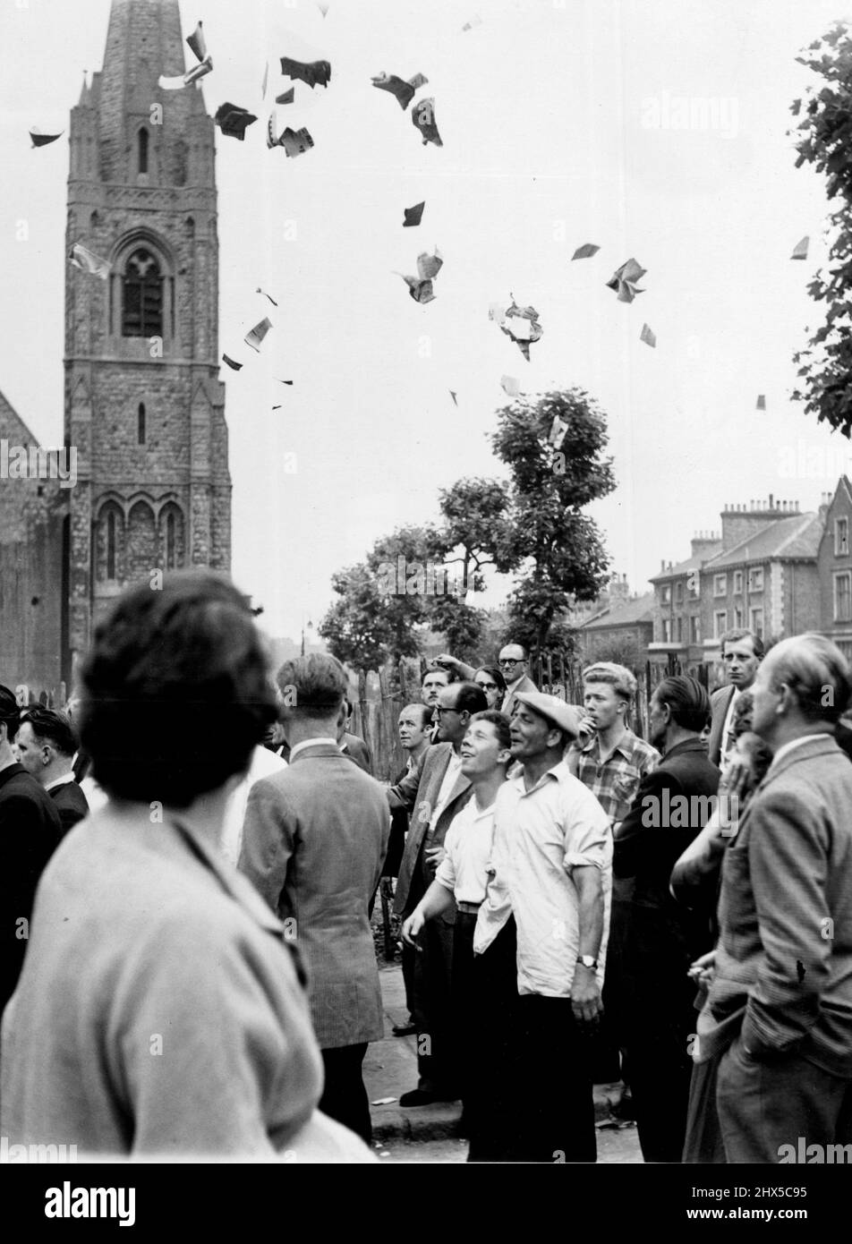 Als die Mitteilungen veröffentlicht wurden, warfen zwei Männer in der Menge diese zerrissenen Zeitungen (hier zu sehen) in den Sir und riefen 'ein weiterer Mord'. Ruth Ellis wurde heute im Holloway Gefängnis wegen des Mordes an ihrem 25-jährigen Geliebten David Blakely gehängt. Hunderte von Menschen warteten vor dem Gefängnis. Drei berittene Polizisten und 15-Fuß-Polizisten mit verbundenen Waffen bewachten den Eingang des Gefängnisses, während andere Polizisten die Parkhurst-Straße umsäumten, um die verwahrten Massen zurückzuhalten. 13. Juli 1955. (Foto von Daily Mirror). Stockfoto