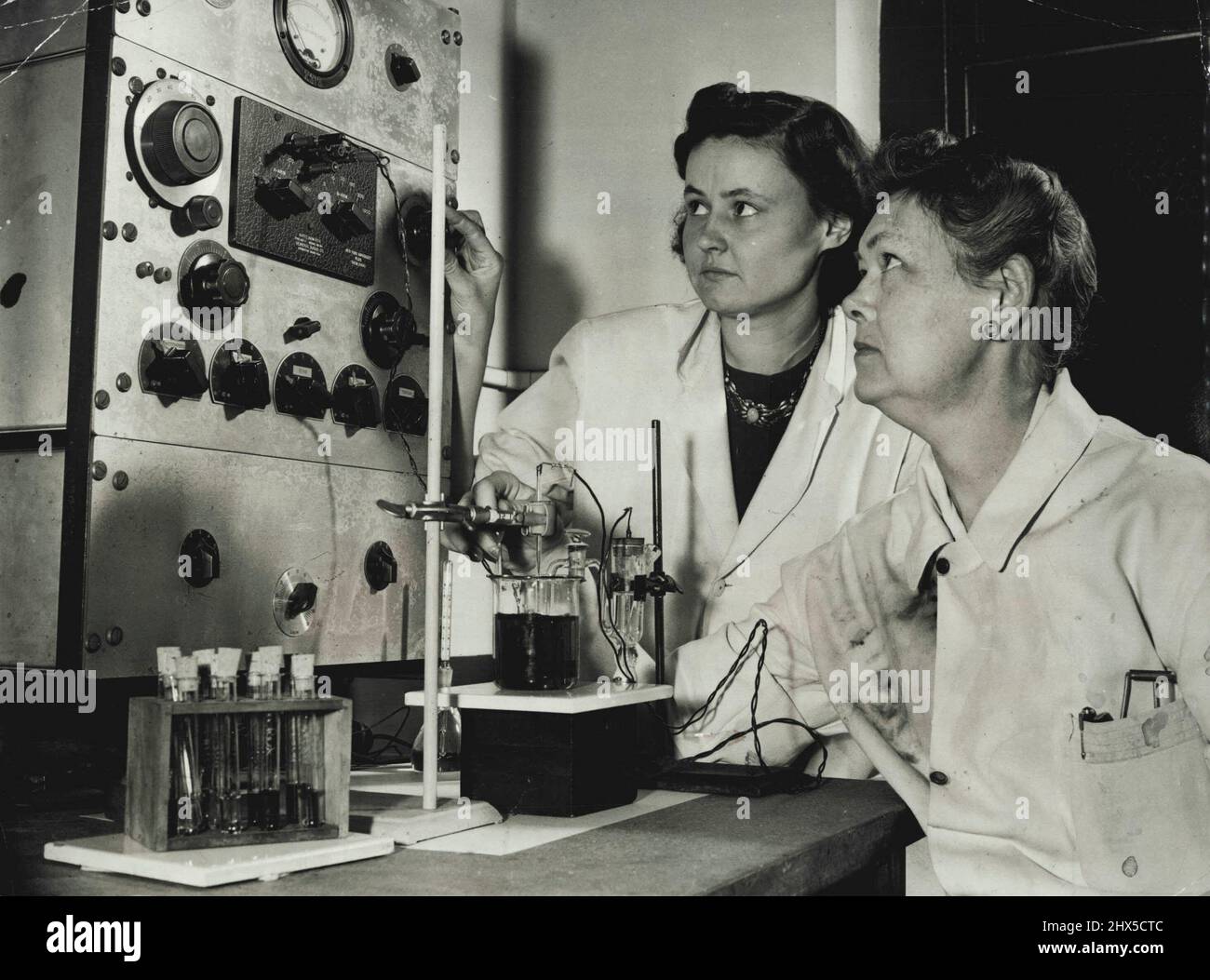 Clock Watchers.....eigentlich beobachten die Labordamen keine Uhr, sondern ein Voltmeter, das die Spannung einer elektrochemischen Zelle aufzeichnet. Dies ist ein weiterer Apparat, mit dem sich die Studenten der Chemie und Physik vertraut machen müssen. 18. Juli 1943. (Foto von International News Photos). Stockfoto