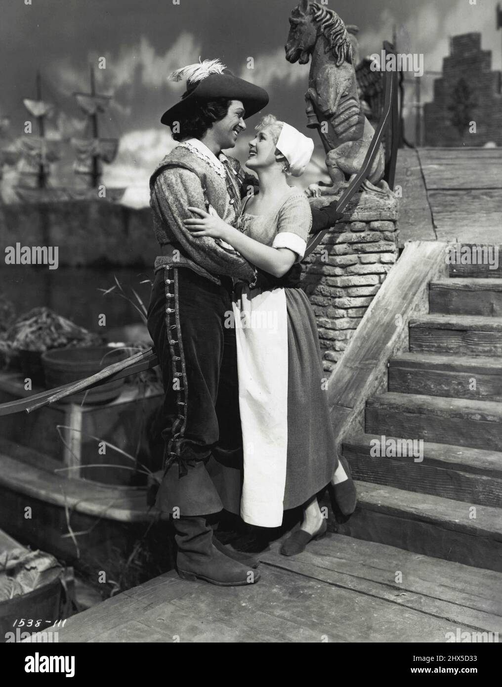 The Exile - Charles (Douglas Fairbanks) und Katie (Paule Croset) machen einen Spaziergang durch den Marktplatz, um die Lastkähne beim Laden zu beobachten. Douglas Fairbanks und Paule Croset, Co-Star mit Maria Montez in 'The Exile' (Lyeeum). 19. Dezember 1947. (Foto von Universal-International). Stockfoto