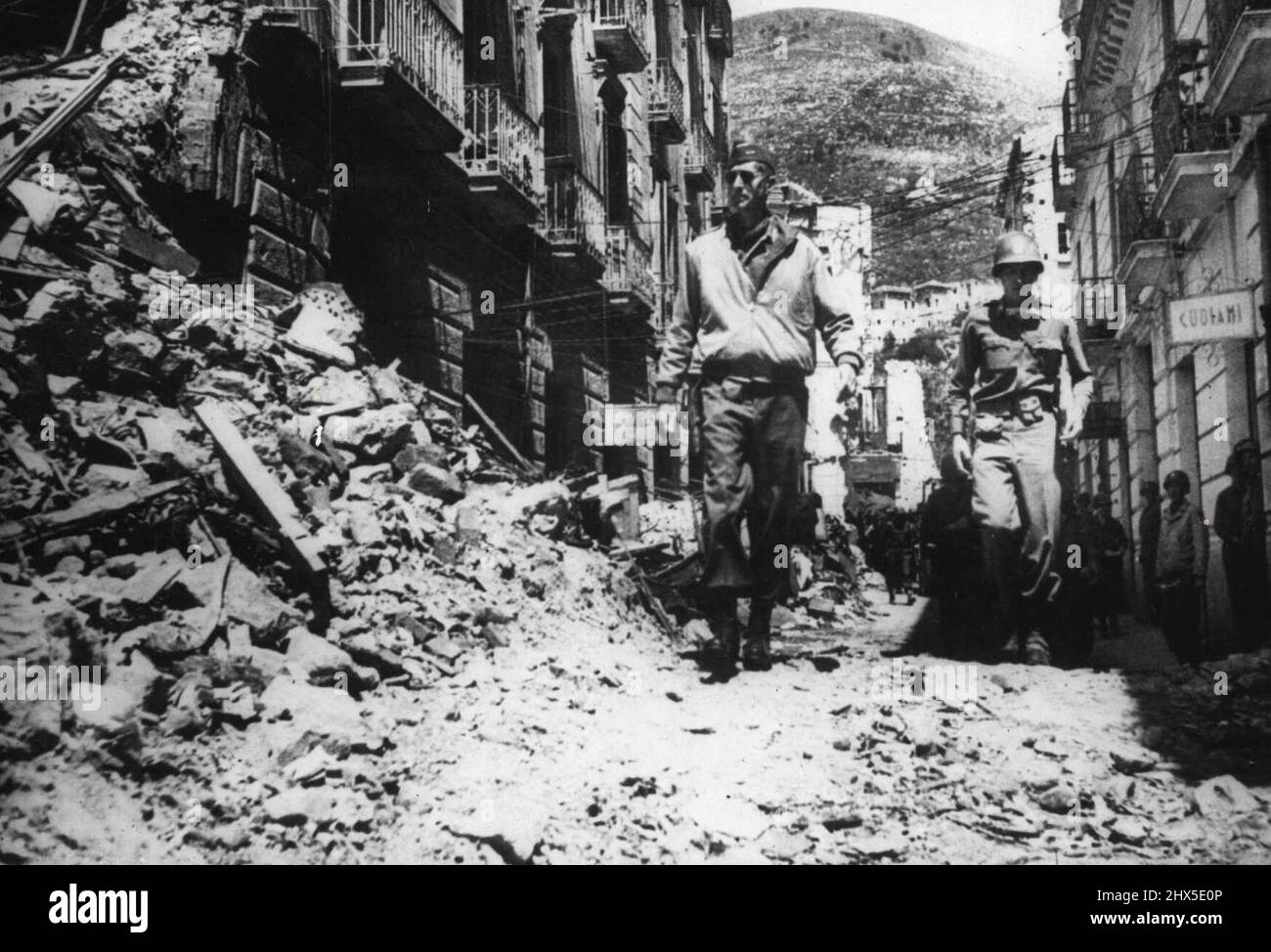 General Clark auf dem italienischen Schlachtfeld Foto zeigt:- General Mark Clark, Kommandant der Fünften Armee, geht durch eine schuttgefüllte Straße, die Schauplatz schwerer Kämpfe während der Schlacht um ein Dorf zwischen Formuia und Itri war, auf dem Highway 7, Italien. 31.Mai 1944. Stockfoto