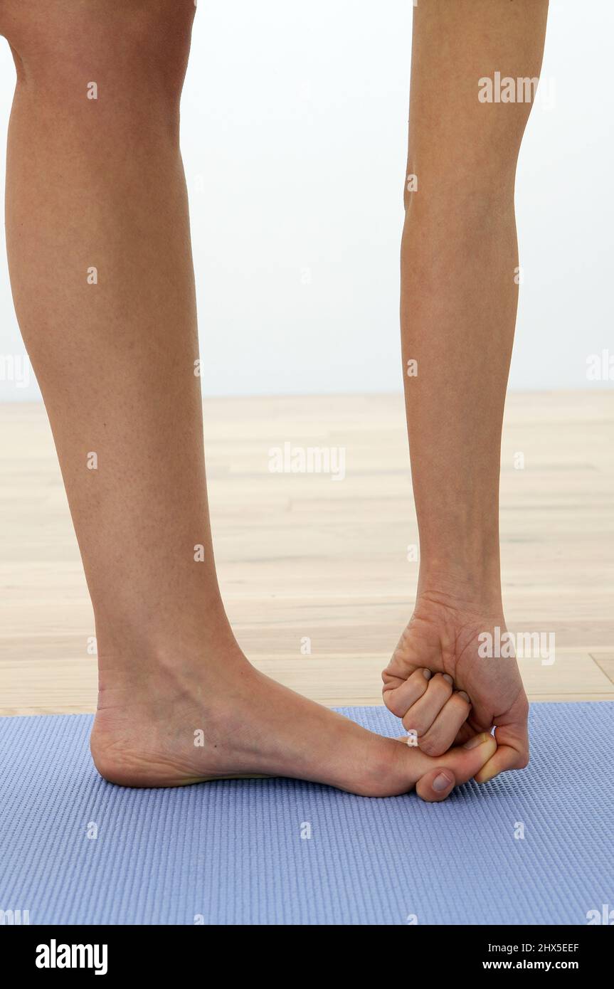Hand hält großen Zeh, nach vorne beugen Yoga-Pose Stockfoto
