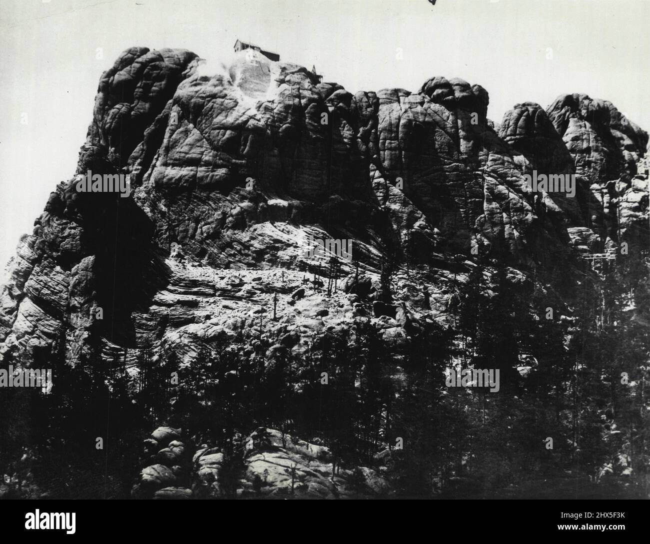 Ein Denkmal, das durch die Jahrhunderte andauert: Ein Blick auf den Rushmore Mountain, der sich in den schwarzen Hügeln von South Dakota befindet, aus dem kolossale Köpfe von Washington, Jefferson, Lincoln und Roosevelt geschnitzt werden sollen, um als nationales Denkmal für Generationen zu gelten. Steinarbeiter unter der Leitung von Gutzon Borglum, einem bekannten Bildhauer, haben bereits begonnen, die riesige Granitmasse für die erste der vier Figuren, die von Washington, einzuschneiden. Neben den vier großen Köpfen wird eine fünfhundert Worte lange Geschichte der Vereinigten Staaten, geschrieben von Ex-Präsident Calvin Coolidge, in die Oberfläche des Berges geschnitten werden Stockfoto