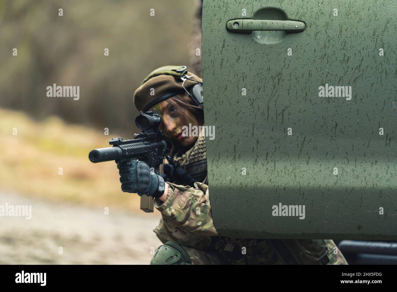 Fiese feminine Soldatin, die sich auf das Verstecken des Ziels Hochwertige Fotos Stockfoto