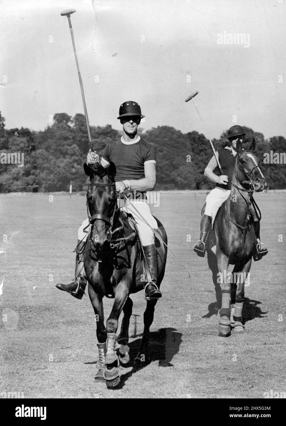 Das britische Paar „Sporting Royal“ – ihre Königlichen Hoheiten Prinzessin Elizabeth und der Herzog von Edinburgh Ein begeisterter Polospieler und Reiter der Herzog von Edinburgh erhebt seine Stöcke, als sein Team, Maidensgrove, das Spiel gegen Hertfordshire, den Poloclub „St Sutton Park“, Guildford surrey, gewinnt. Sie nahmen im Juli 1951 am Cowdray Park Junior Challenge Cup Teil. 13. Januar 1954. (Foto von Sport und General Press Agency Limited). Stockfoto