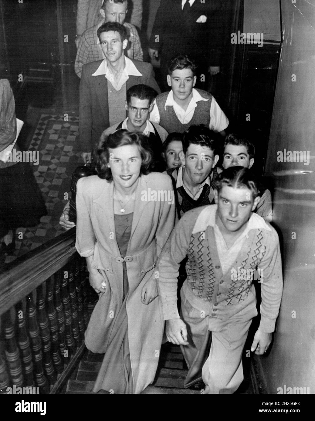 Ansturm Von Freiwilligen. Trainer und Jockey von der Rennbahn Moorefield gehörten zu den vielen, die auf einen Aufruf des Rotkreuz-Bluttransfusionsdienstes an Spender reagierten, der 18-jährigen Joyce Hanna, Tochter des Pferdetrainers von Moorefield, George Hanna, und einem Mann im St. George District Hospital, die beide schwer verbrannt wurden, zu helfen. Rechts führt Jockey George Podmore die Freiwilligen die Treppe hinauf zur Blutbank. 24. Februar 1949. Stockfoto