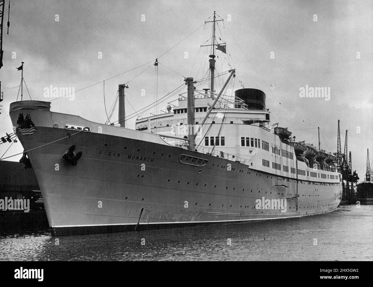 Ocean Monarch in Tilbury -- mit einer 'König Neptun'-Galionsfigur am Bug hat der 'Ocean Monarch' vor dem Segeln in letzter Minute Vorbereitungen getroffen (Malergerüst ist noch über der Seite). Heute segelt der neue, für Massrs gebaute Liner Ocean Monarch (ca. 14.000 Tonnen) von Tilbury nach New York, um sich dem Kreuzfahrtverkehr anzuschließen. Furness mit und Company ist der neue Liner das erste große Schiff, das speziell für den Kreuzungsverkehr in Großbritannien seit dem Krieg gebaut wurde. Sie hat Unterkünfte für 40 Passagiere der 1-Klasse und wird dem Passagierschiff Queen of Bermuda während der geschäftigen Saison der New York-Bermuda behilflich sein Stockfoto