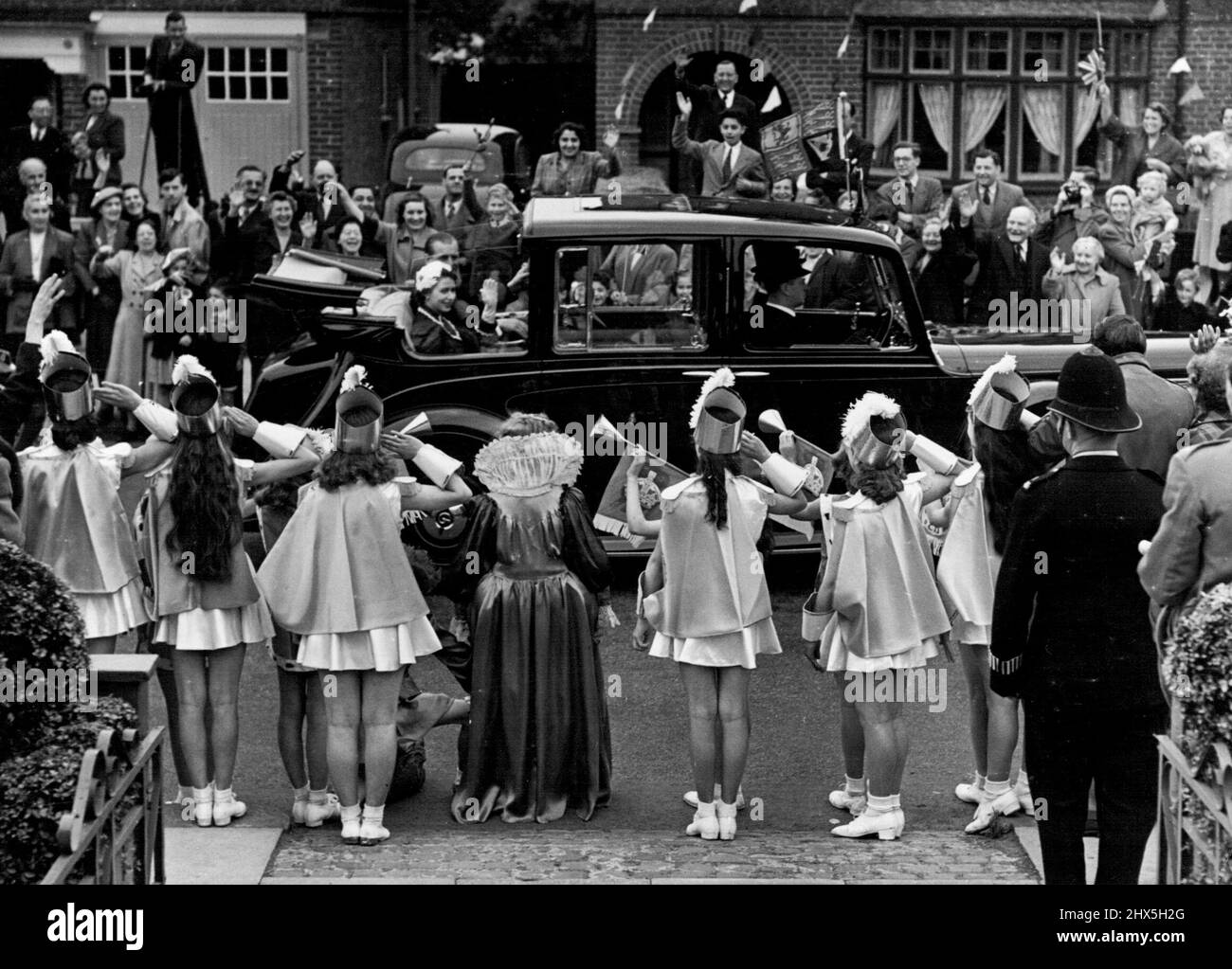Grüßen und eine Fanfare von Trompeten... Dies war die Szene, als 'Queen Bess' und ihr 'Court' - Children of Acton - die Königin und den Herzog von Edinburgh begrüßten. Die Queen und der Duke winken mit Freude zurück, als sie gestern auf ihrer Krönungsreise durch den Nordwesten Londons langsam an einem offenen Auto vorbei fahren. Den ganzen Tag lang „die Leute“. 05. Juni 1953. (Foto von Daily Mirror). Stockfoto