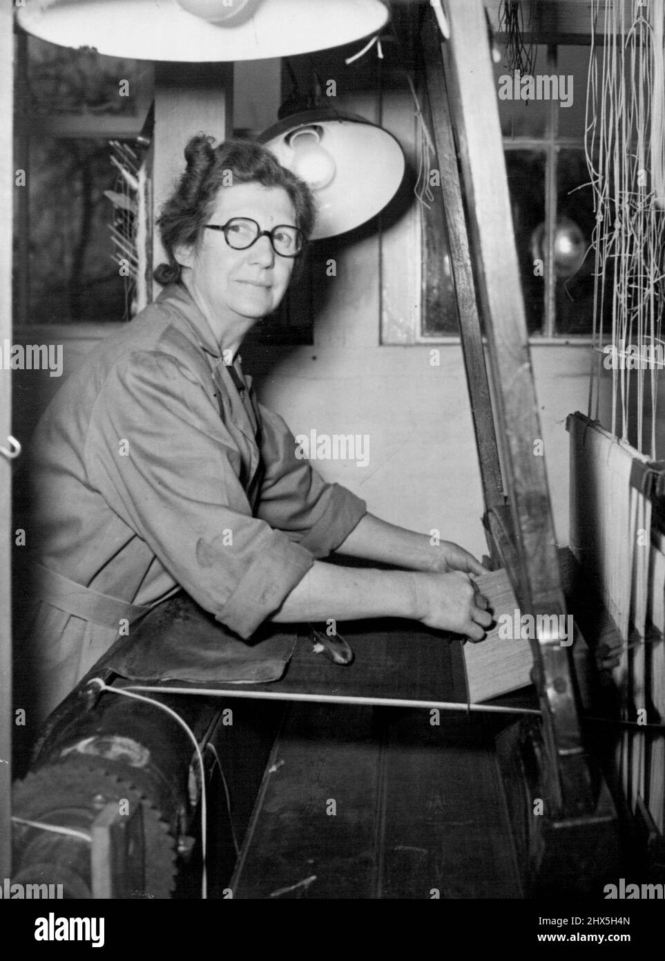 Hilft beim Weben von Samt für die Krönungsröbe der Königin. Frau Hilda Kalver arbeitet heute in Braintree Mühlen. Weberinnen begannen heute (Dienstag) den halben Yard eine Tagesaufgabe, die 20 Yards Samt für die Krönungsrobe der Königin in den New Mills of Warner & Sons, Limited, in Braintree, Essex, zu machen. Der Samt, ganz Seide, wird 21 Zoll breit sein. Es wird von Miss Lilly Lee, die die Krönungsrobe für Königin Elizabeth, die Königin Mutter, und Mrs. Hilda Carver gewebt. 18. November 1952. (Foto von Reuterphoto). Stockfoto