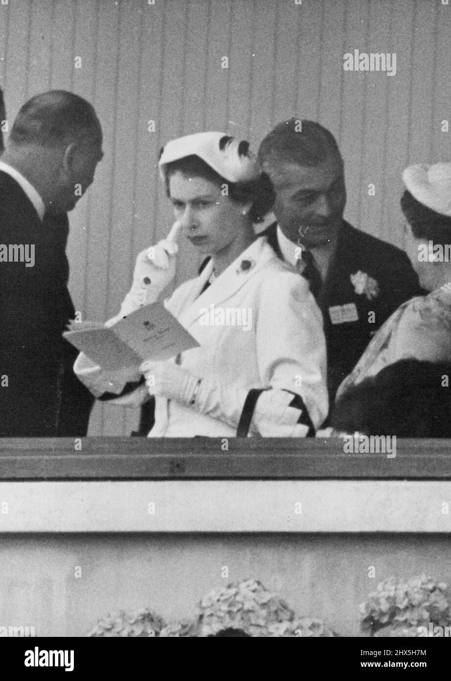 Die Königin in nachdenklicher Stimmung bei Ascot. Ihre Majestät, die Königin, legt ihren Finger nachdenklich auf ihre Wange, während sie heute ihre Rennkarte in der Royal Box in Ascot studiert. Ihre Majestät war heute weiß gekleidet. 18. Juni 1953. (Foto von Fox Photos). Stockfoto