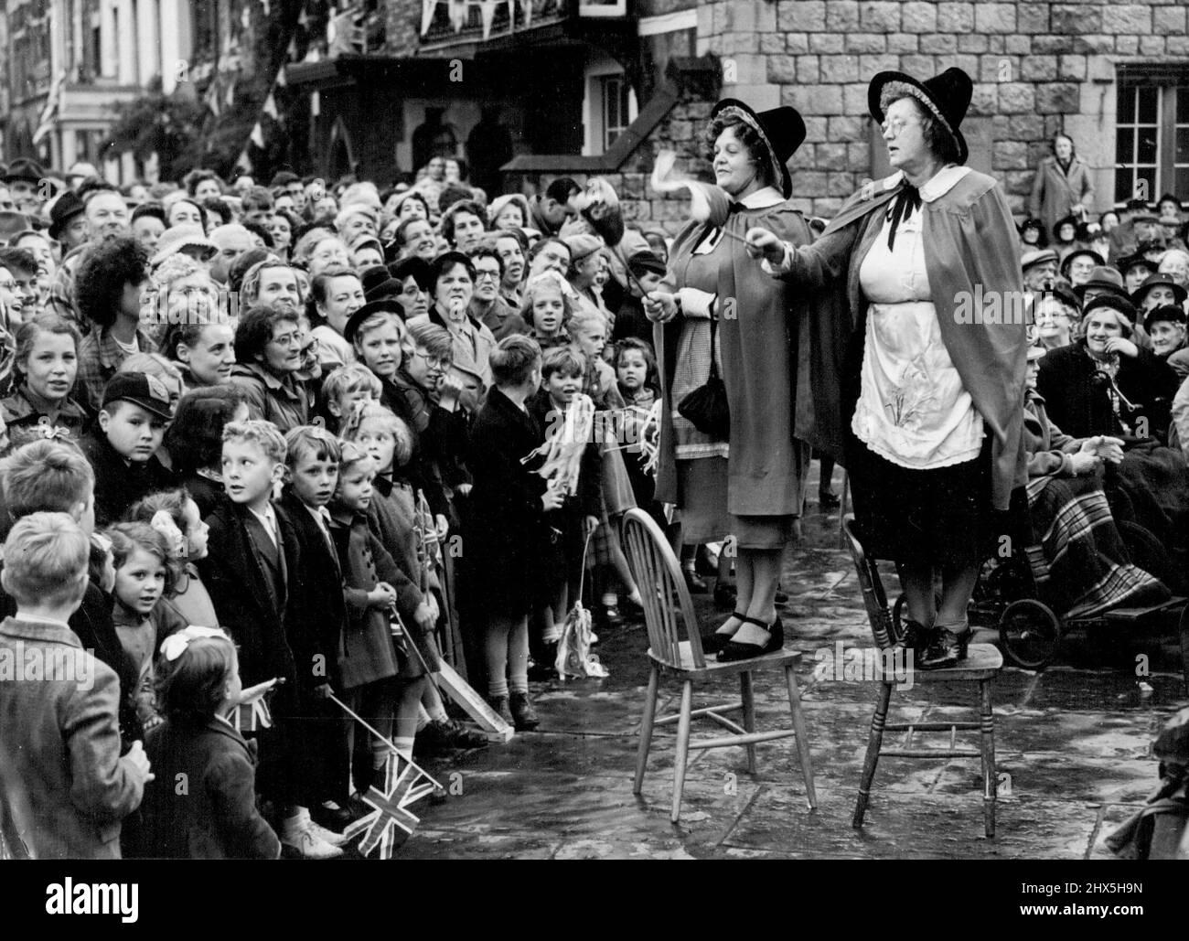 Höhepunkt des Besuchs der Königin in Wales. Walisische Frauen in Nationaltracht führen den Chor an, der die Königin willkommen heißt, als sie in Caernarvon ankommt. Gestern war der Höhepunkt des Krönungsbesuchs der Königin in Wales. Das wichtigste Element der Feierlichkeiten des Tages war der Besuch der Königin im Schloss Caernarvon. In einem Pavillon, der in dem stattlichen Hof, flankiert von den großen Mauern dieser mittelalterlichen Bastion, errichtet wurde, empfing ihre Majestät viele Würdenträger aus Nordwales. 11. Juli 1953. (Foto von Paul Popper). Stockfoto