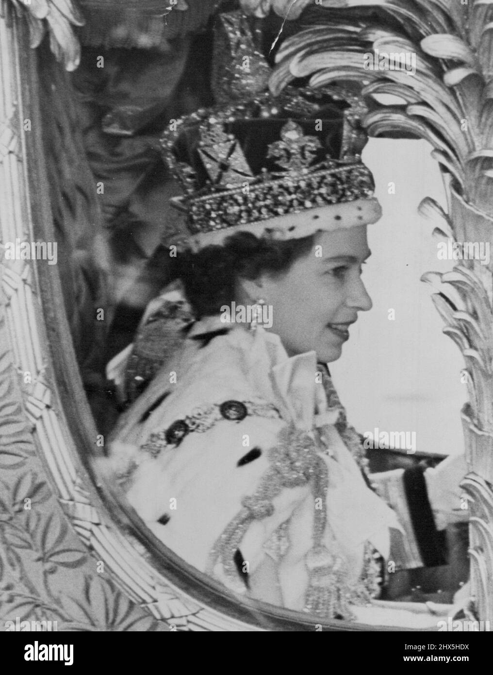 Unsere lächelnde Königin fährt in Prozession durch die Straßen Londons. Eine Nahaufnahme der frisch gekrönten Königin, die die kaiserliche Staatskrone trägt und ihr sonniges Lächeln dem grauen Wetter trotzt, während ihrer Prozessionsfahrt nach ihrer Krönung heute Nachmittag. 02. Juni 1953. (Foto von Fox Photos). Stockfoto