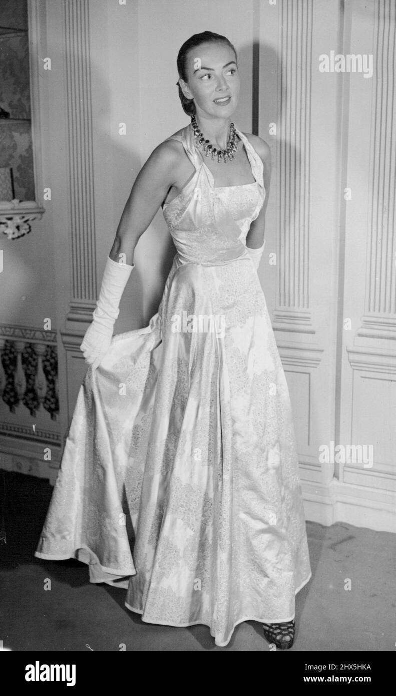 In 'Coronation' Brocade -- Gewand, um alle Augen zu fangen, auch zur Krönungszeit, ist dieses schöne Ballkleid von Angele Dolenghe entworfen. Es ist in grauem, weißem und silbernem „Krönungsbrokat“. 18. Dezember 1952. (Foto von Reuterphoto). Stockfoto