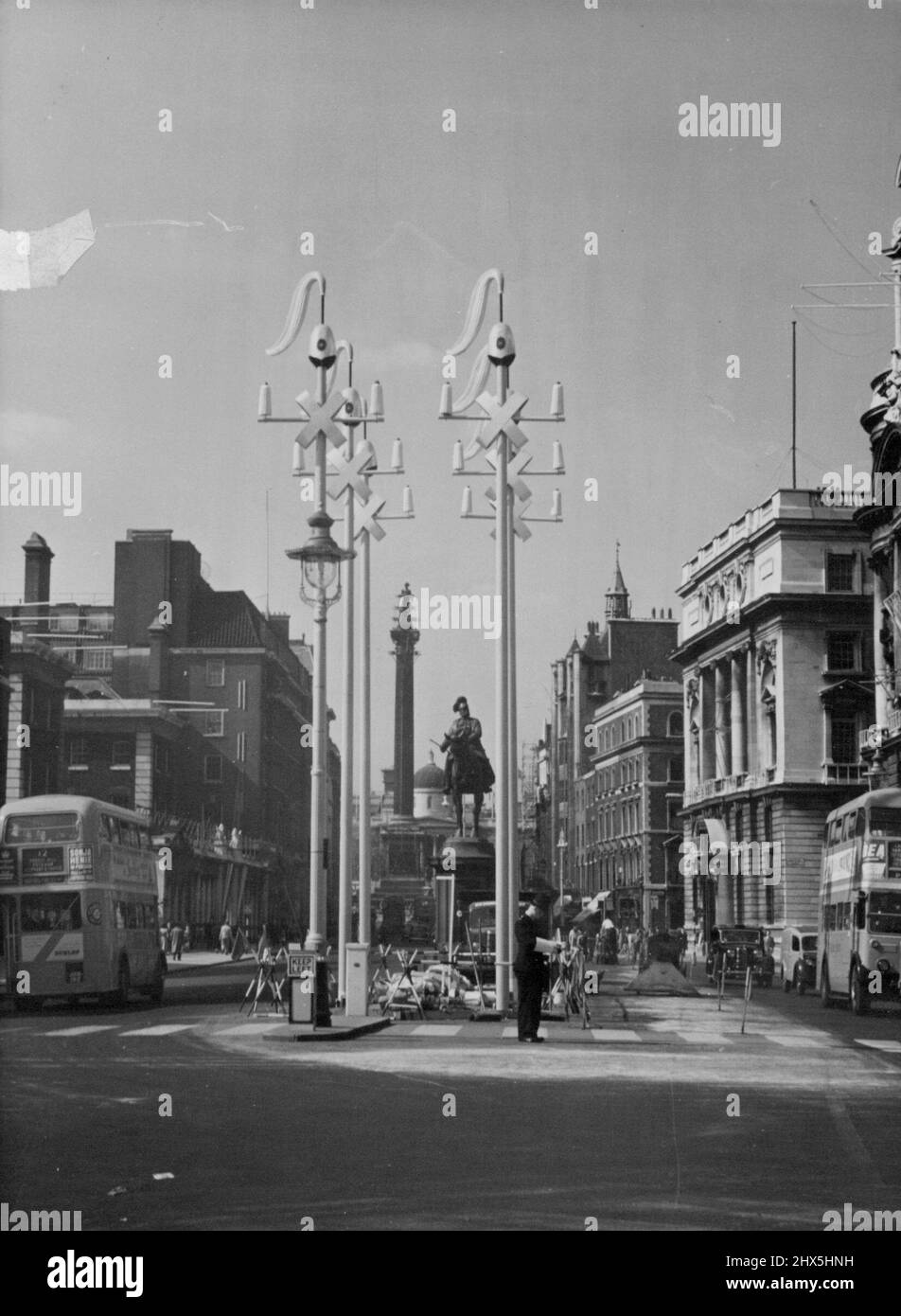 Horseguard-Dekorationen in Whitehall - eine Gruppe von sechs Horseguard-Dekorationen, die in Whitehall errichtet wurden. Diese Ansicht wird in Richtung Trafalgar Square genommen und die Nelson-Säule, die angeprangt wird, ist im Hintergrund zu sehen.die Dekorationen für Whitehall, in Form eines Horseguards Haarnetzes und eines Plumos mit Quergurten, montiert auf Standards, werden jetzt in Whitehall, London, errichtet. Es ist entlang dieser Route, die die Königin nach ihrer Krönung fahren wird. 13.Mai 1953. (Foto von Fox Photos). Stockfoto
