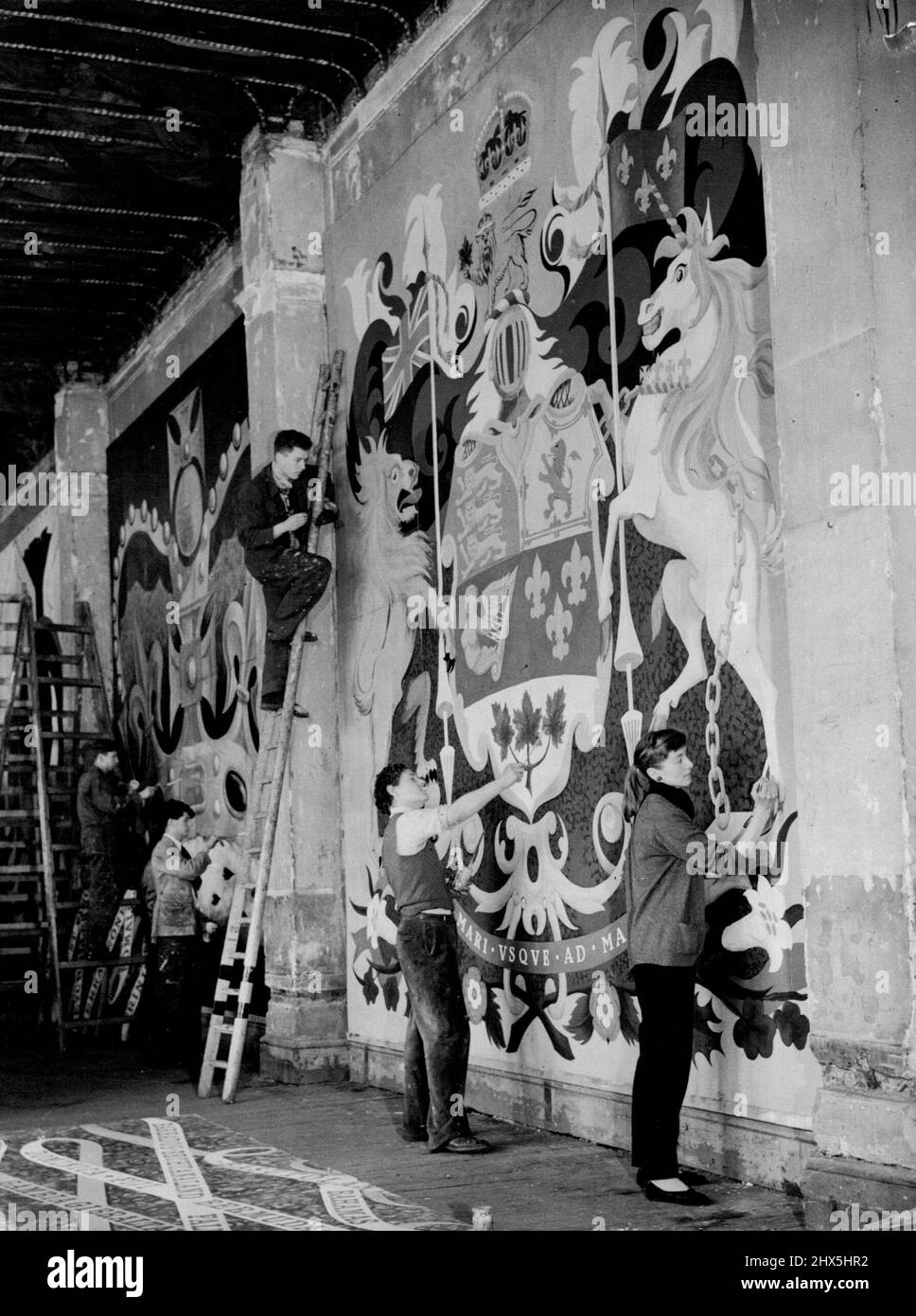 Kanadisches Emblem für Londoner Krönungsdekorationen -- Studenten arbeiten heute (Dienstag) am riesigen kanadischen Emblem im Victoria and Albert Museum in London. Links arbeiten andere Studenten an einer der riesigen Kronen für den Commonwealth-Stand. Die großen Embleme der acht selbstverwalteten Länder des Commonwealth werden Teil der Krönungsdekorationen in London sein. Diese werden für das Werkministerium von einem Team junger Künstler unter der Aufsicht von kenneth Rowntree, einem Tutor am Royal College of Art, gemalt. 28. April 1953. Stockfoto