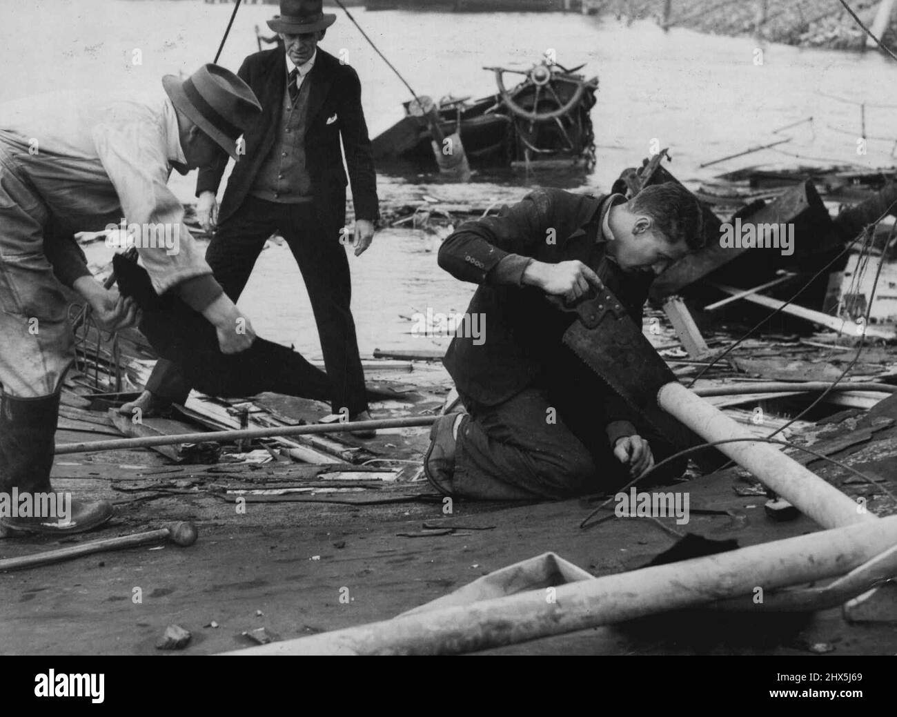 Arbeiter waren heute damit beschäftigt, Trümmer aus der Explosion eines japanischen Torpedo zu entfernen, der am Sonntagabend den Fährdampfer zerstörte. Sie sind hier auf dem Dach des Oberdecks eingekuppelt zu sehen. Das Zahnrad ist hinten zu sehen. 10. Juni 1942. Stockfoto