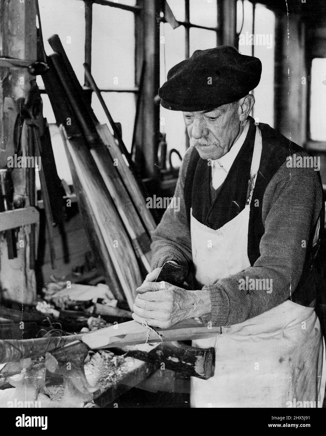 Famous bat - Maker's Shed soll vor dem Oval abgerissen werden - ***** Killick bei der Arbeit in seinem Schuppen an der Rückseite seines Hauses in der Clayton-Straße, der demnächst abgerissen werden soll. Der alte Schuppen vor dem Oval, ein Resort berühmter Cricketspieler seit 60 Jahren oder mehr, soll in Kürze abgerissen werden, um Platz für einen Block neuer Wohnungen in L.C.C. zu schaffen. Der Schuppen ist im Besitz von Albert Killick, dem letzten überlebenden Mitglied einer berühmten Batmaker-Firma. Wer sammelt seine Werkzeuge, bereitet sich auf den Umzug in neue Geschäftsräume vor. 9. April 1934. (Foto von Associated Press). Stockfoto