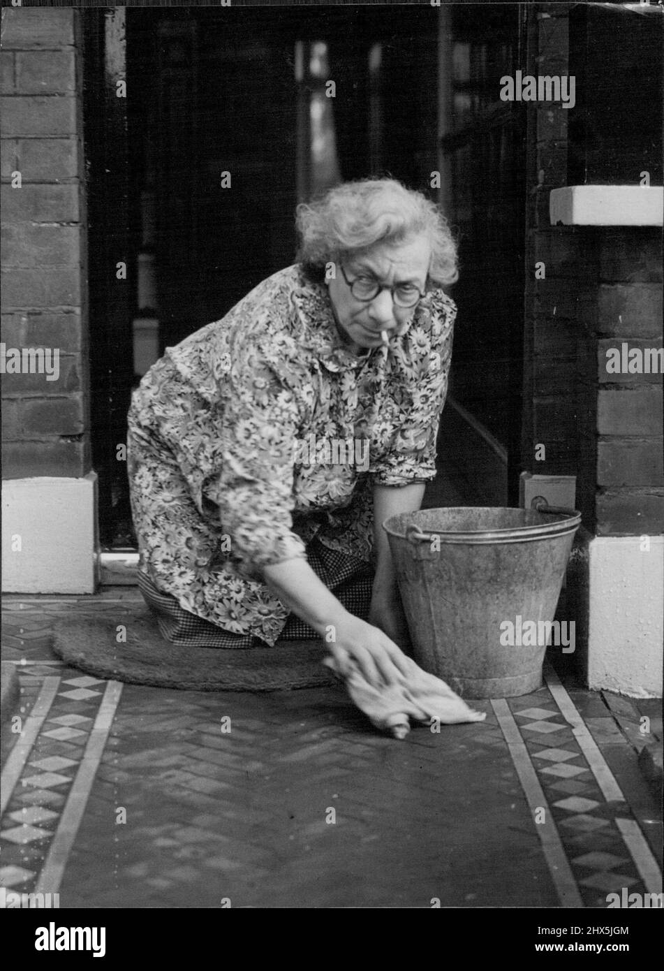 Nicht stolz - Haus stolz Sie ist die Frau des Kabinettsministers, aber sie ist kein Snob. Frau Emmanuel Shinwell Ehefrau des Ministers für Kraftstoff und Strom Waschen der gefliesten Weg zum Vordereingang des kleinen Hauses in Beechcroft Road, Tooting, London, wo sie und ihr Mann leben. Frau Shinwell erledigt ihre eigenen Einkäufe und Hausarbeiten. Die Shinwells feierten letzte Woche ihren 44.. Hochzeitstag. 18. Oktober 1946. (Photo by Mirror Features). Stockfoto