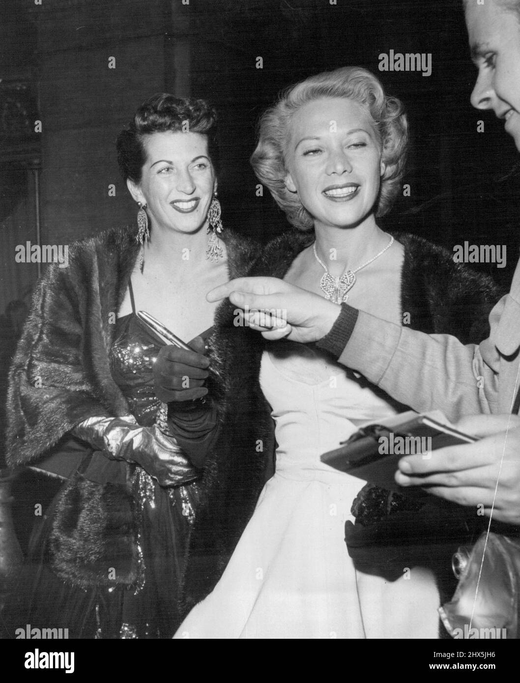 Dinah Shore und Mrs. Van Johnson wurden von Autogrammjägern an der Tür angehalten. 9. Februar 1953. Stockfoto
