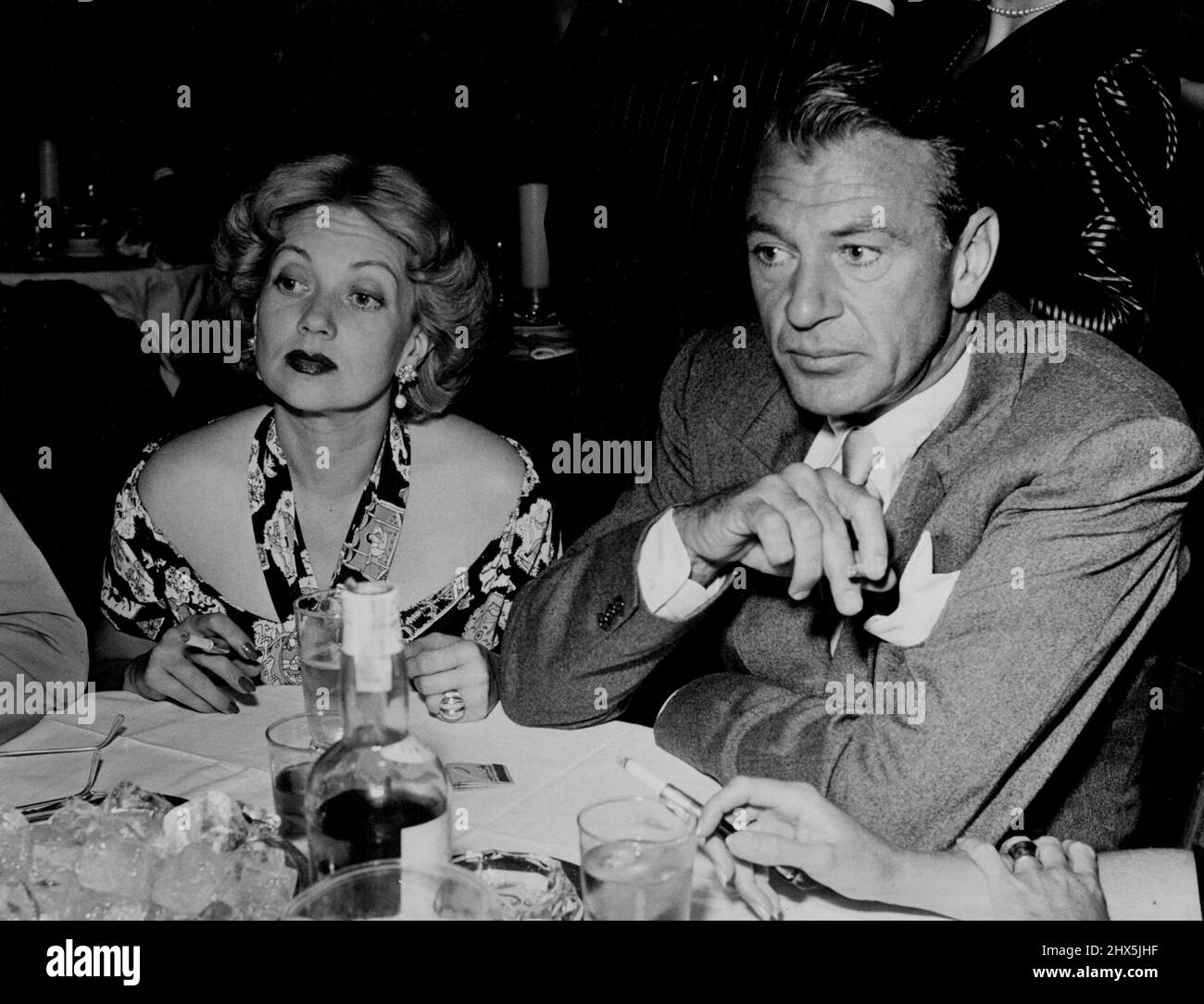 Gary Cooper und Ann Sothern, die kürzlich Robert Sterling vergossen haben, nur eine halbe Gruppe von vier Personen. Der Zigarettenhalter rechts gehört Veronica Cooper und Coop geht nie ohne sie auf Partys. 27. Oktober 1948. Stockfoto