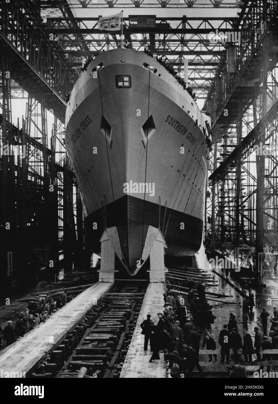 Die Queen Trägt Outfit To Match Ship - Das Southern Cross ***** Gestern den Slipway bei Balfast runter. Die Queen trug gestern einen Princess Line-Mantel und einen passenden Hut in Pastellgrün - die gleiche Farbe wie die Oberarbeiten des Liners, den sie in Belfast lanciert hatte. Während sie darauf wartete, den Starthebel zu ziehen, stand die Königin unter einem Canvas-Baldachin, das sich unter dem Gewicht des Regenwassers ausdehnete. Sie lächelte, als Lord Brookeborough, der Premierminister von Nordirland, der neben ihr stand, auf die bedrohliche Wölbung zeigte und sagte: „Ich hoffe, das kommt nicht durch.“ 18. August 1954. Stockfoto