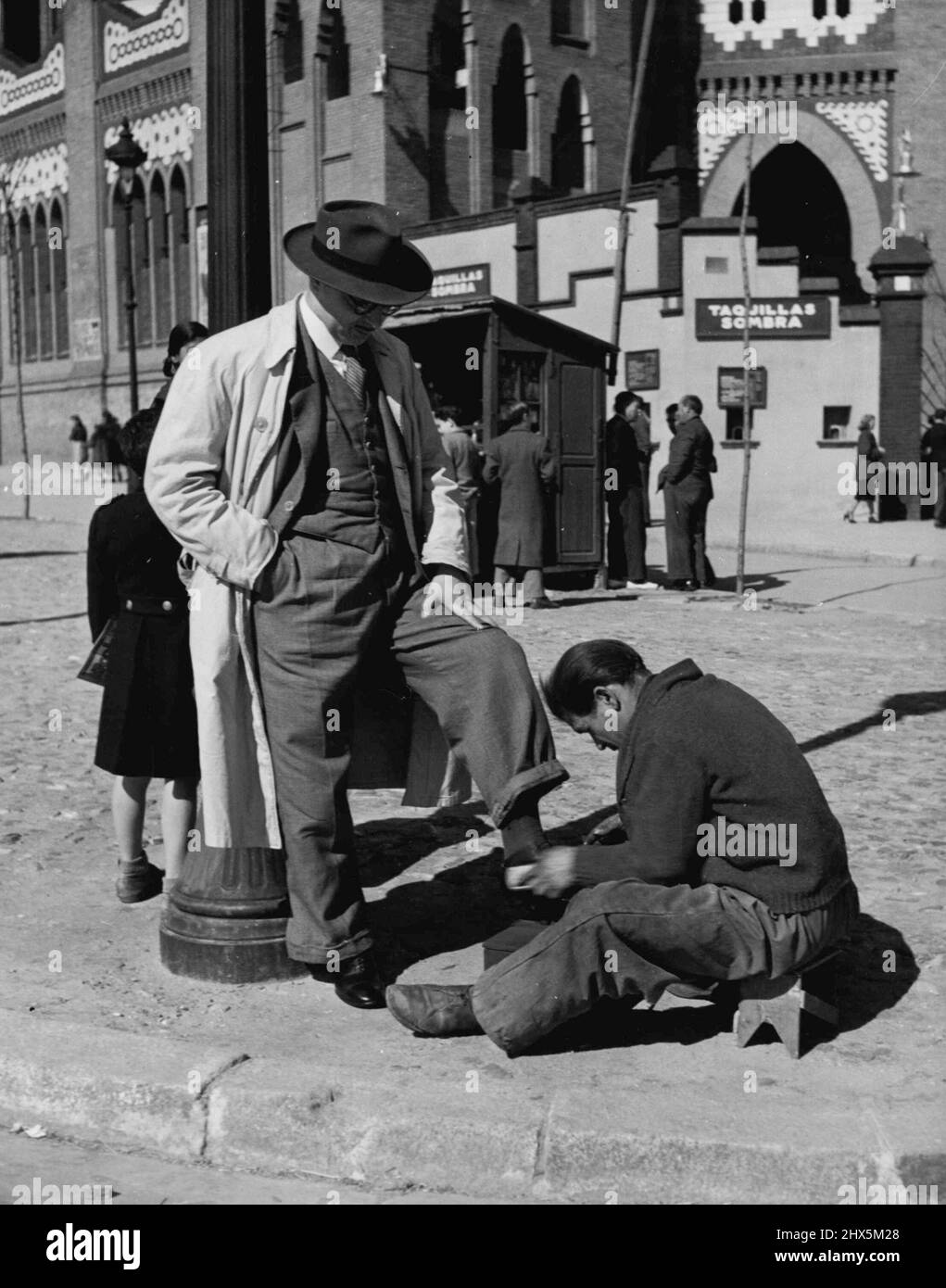 Franco's People -- viele Aktivitäten konzentrieren sich auf die Stierkampfarena - und es gibt immer einen schuhputzservice. Er wird sicherlich noch eine andere Beschäftigung haben, außer Schuhe zu putzen, oder er wird in der Nacht den gleichen Job für ein Hotel machen - denn niemand in Spanien könnte seinen Lebensunterhalt von glänzenden Schuhen bestreiten. 30. September 1949. (Foto von Steven Henty, Pictorial Press). Stockfoto