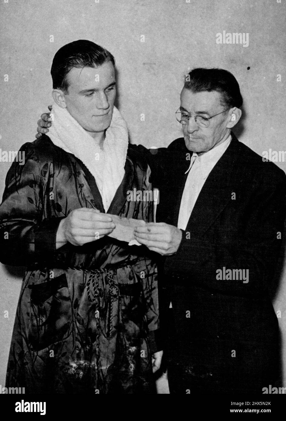 Sie ließen Boxer Danny Sewell nicht den Kampf weiterführen, für den er am 21. Oktober in der Albert Hall, London, geplant war, bis er eine Geburtsurkunde vorlegte, um zu beweisen, dass er tatsächlich unter 15 Jahre alt war, wie er behauptete. Das Dokument an einen Beamten der Areie Boxer's Association, der überzeugt war. Danny wurde im Ring zugelassen und gewann seinen Kampf gegen Victor Simpson, der mitteweight Schoolboy Danny wiegt 11 Steine 9 Pfund. 3. Dezember 1945. (Photo by Mirror Features). Stockfoto