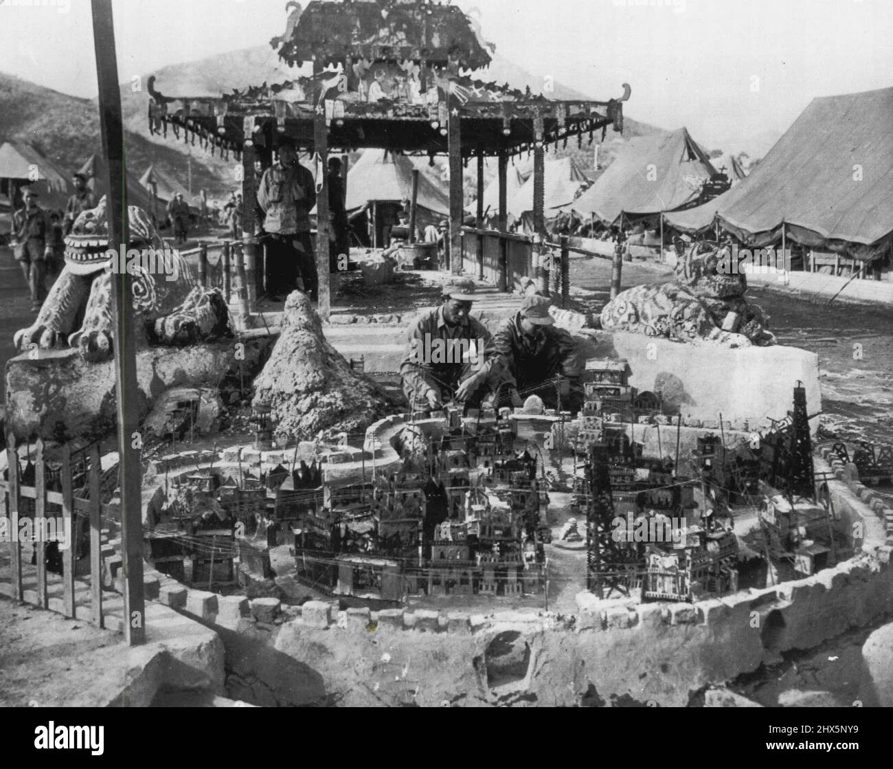 Modelldorf im Roten Gefangenenlager -- zwei gefangene kommunistische Soldaten in einem Kriegsgefangenenlager auf der Insel Koje vor der Küste Südkoreas arbeiten an einem Modell ihres Heimatdorfes auf dem chinesischen Festland. Das Modell bestand aus Steinen, Bierdosen und. Andere Quoten und Enden. Das Lager Koje Pow hat 120.000 in Haft, davon 18,000 Chinesen. 20. November 1951. (Foto von AP Wirephoto). Stockfoto