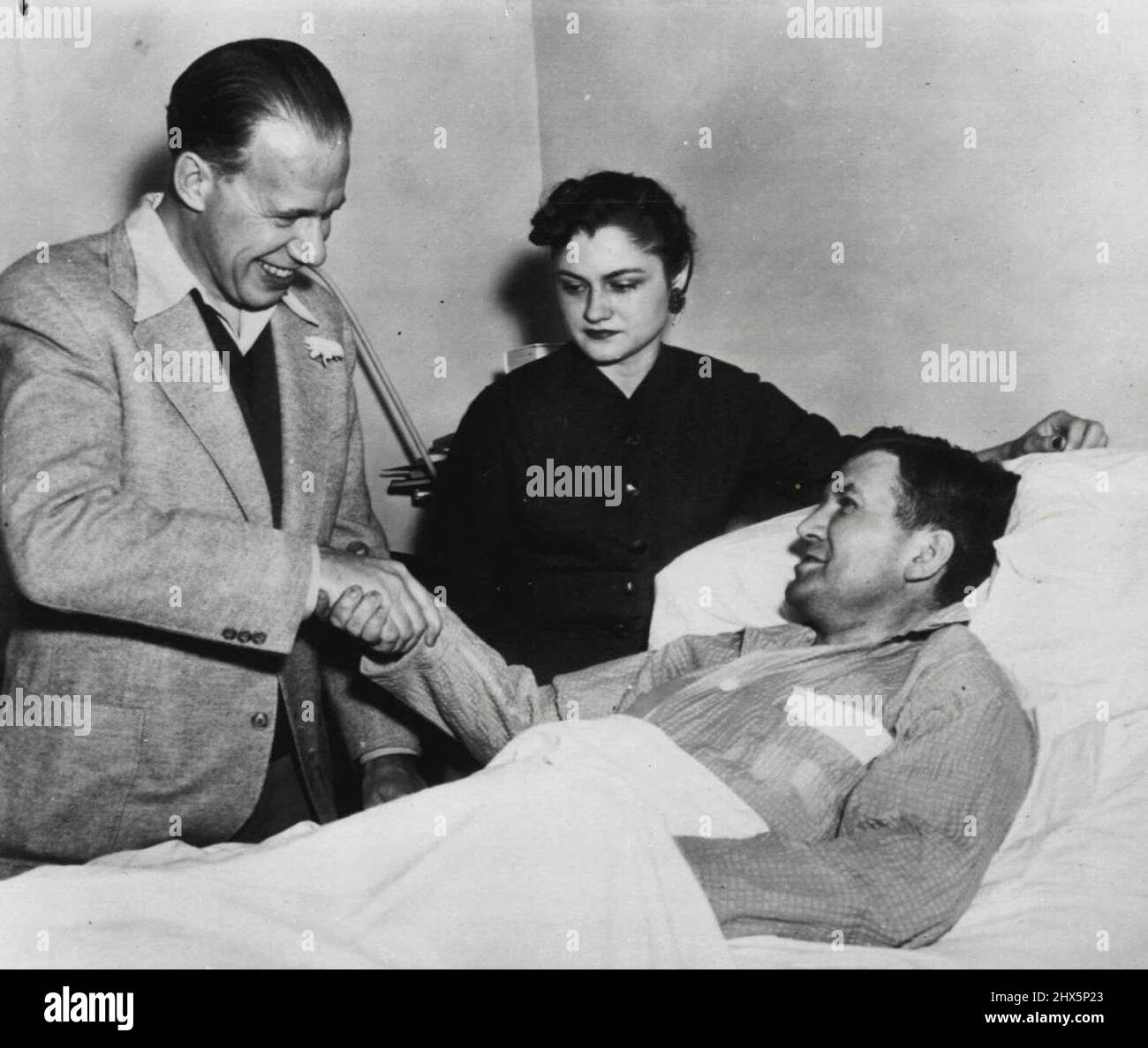 Ein Schießsopfer sagt Auf Wiedersehen zu einem anderen - Rep. Alvin M. Bentley (R-mich), links, einer von fünf Kongressabgeordneten, die am 1. März von puertoricanischen Fanatikern verwundet wurden, sagt Auf Wiedersehen zu Rep. Kenneth Roberts (D-Alan), einem anderen der Schießsopfer, kurz bevor Bentley heute aus dem Unfallkrankenhaus entlassen wurde. Frau Roberts steht im Zentrum. Roberts, obwohl er weniger schwer verletzt ist als Bentley, war wegen einer Nervenverletzung „ziemlich unbequem“ und muss im Krankenhaus bleiben, sagte sein Arzt. Er ist der einzige von fünf, die noch im Krankenhaus sind. 28. März 1954. (Foto von AP Wirephoto). Stockfoto