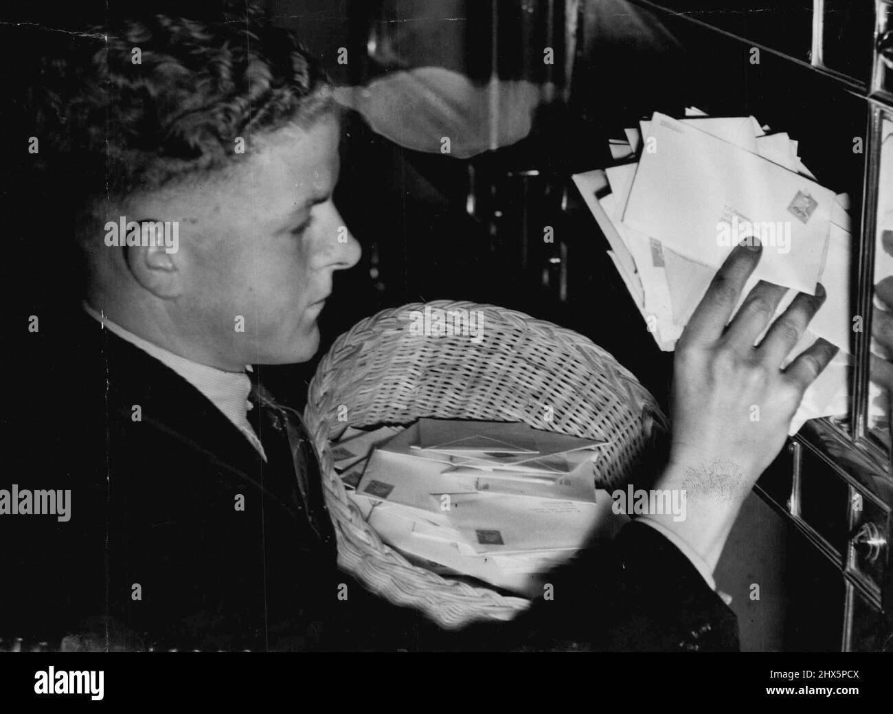 Ein Appell an die Bürger des Commonwealth, sich an einen großartigen Australier zu erinnern. Zweitausendfünfhundert Appellbriefe wurden gestern vom J. M. Dunningham Appellationskomitee beim G.P.O. verschickt, und weitere 1500 werden heute geschickt, um Unterstützung für einen Gedenkfonds zu bitten. Das Bild zeigt einen Jungen, der die riesige Post in eine Kiste leert. 28. Juni 1938. Stockfoto