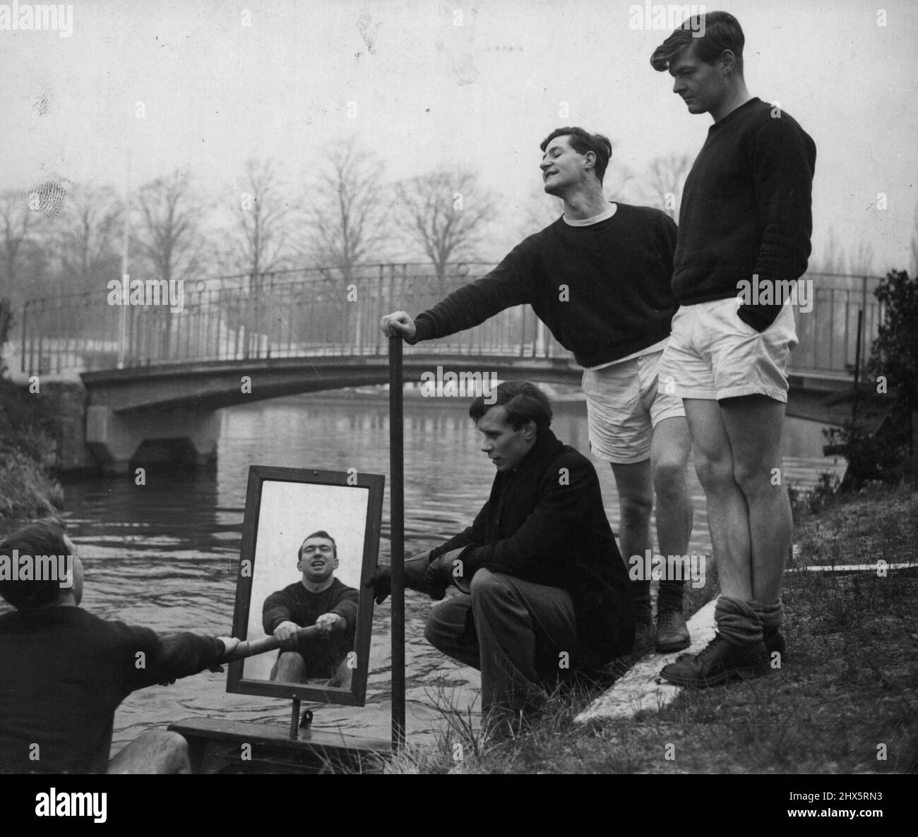 Looking-in on the Boat Race -- Looking-in on boat race practice at Oxford heute (Mittwoch) geben wir euch diese Reflexion über die Fitness für das Inter-Varsity Event Oxford V Cambridge, das am 3. April auf dem Tideway von Putney nach Mortlake gerudert wird. In der festen Wanne übt James Cobbo aus Magdian und Melbourne, Australien, vor dem Spiegel. Ihm zuzusehen sind die ***** Des Oxford Ruderclubs, A.M.C. Schnell (Merton College), gebeugt von David Wells (Magdelen) und rechts von Geoffrey Treasure ***** . James Cobbo, der aus Melbourne und Oxford kommt, hat einen Spiegel, der ihm helfen kann, während er in einer festen „Wanne“ probiert Stockfoto