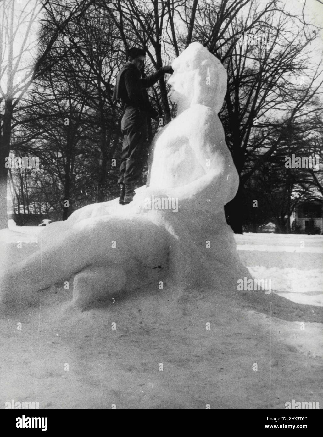Sunny South Snow man -- inspiriert von einem 8-Zoll-Schneefall, gingen Studenten in der Kunstabteilung der University of North Carolina an einem Schneemann arbeiten und hier ist das Ergebnis. Dallas Calowell zeigt, wie er diesem Sphinx-ähnlichen Riesen einen letzten Schliff verleiht. 27. Januar 1946. (Foto von Wide World Photos). Stockfoto