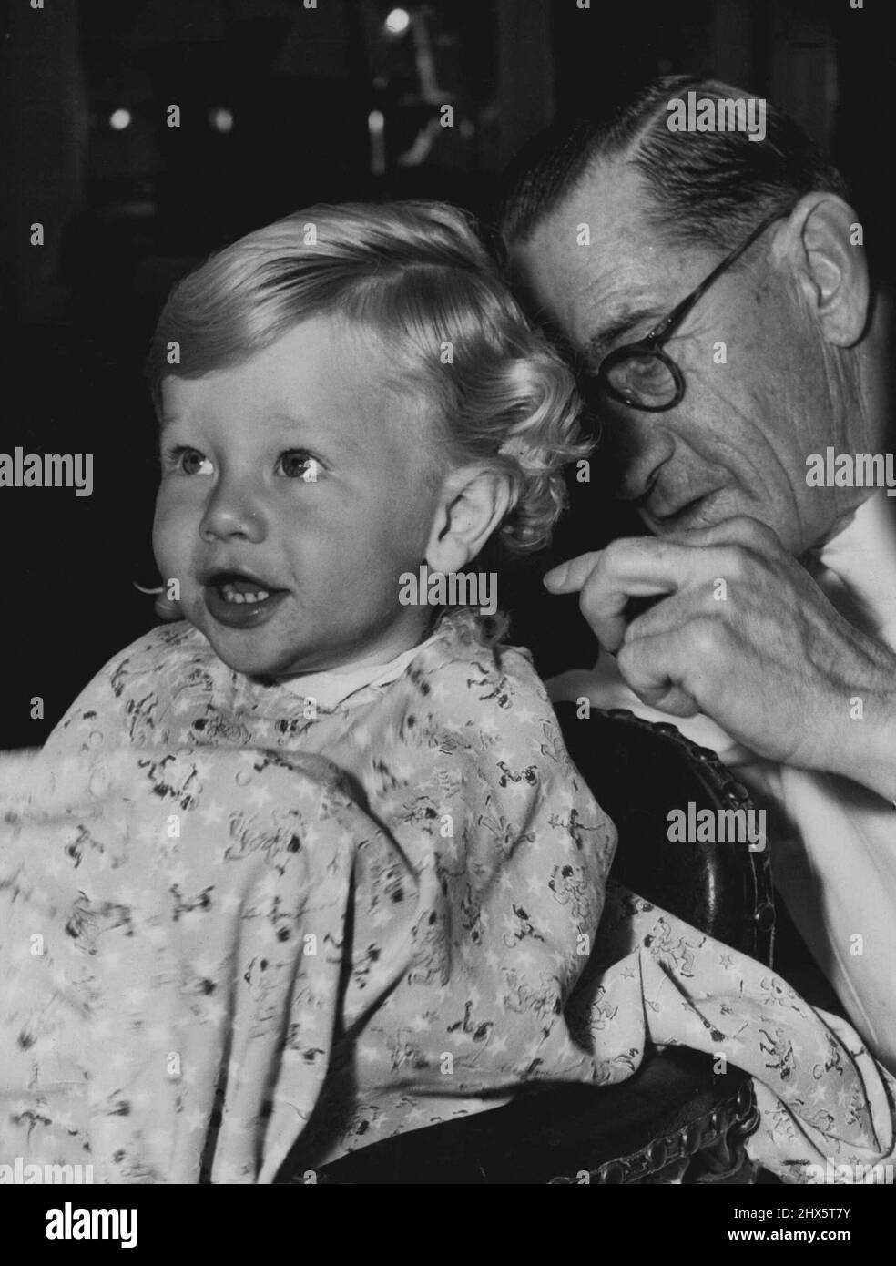 Hoffen wir, dass ich wie ein richtiger Junge aussehen werde, wenn diese saurem Locken abgehackt werden. Colin Talbot, 15, Monate, mit dem süßen Tough-Guy-Ausdruck, musste nicht überredet werden. Er genoss seinen ersten Haarschnitt so sehr, dass er sich weigerte, den Stuhl zu verlassen und von seiner Mutter entfernt werden musste. 14. Juli 1952. Stockfoto