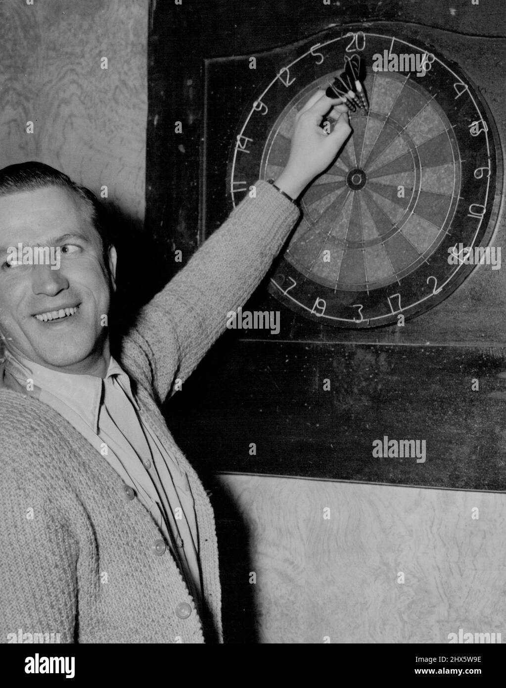 Jim Jess, ein Spieler des Coronation Hotels, zeigt triumphierend seine Punktzahl zwei dreifache 20er (120) und eine 20. Ein DART im Sektor 20 und zwei in der „Triple-20“-Wertung 140. Möglich ist 180. 21. September 1955. Sport, Sport, Athlet, athletisch, Stockfoto