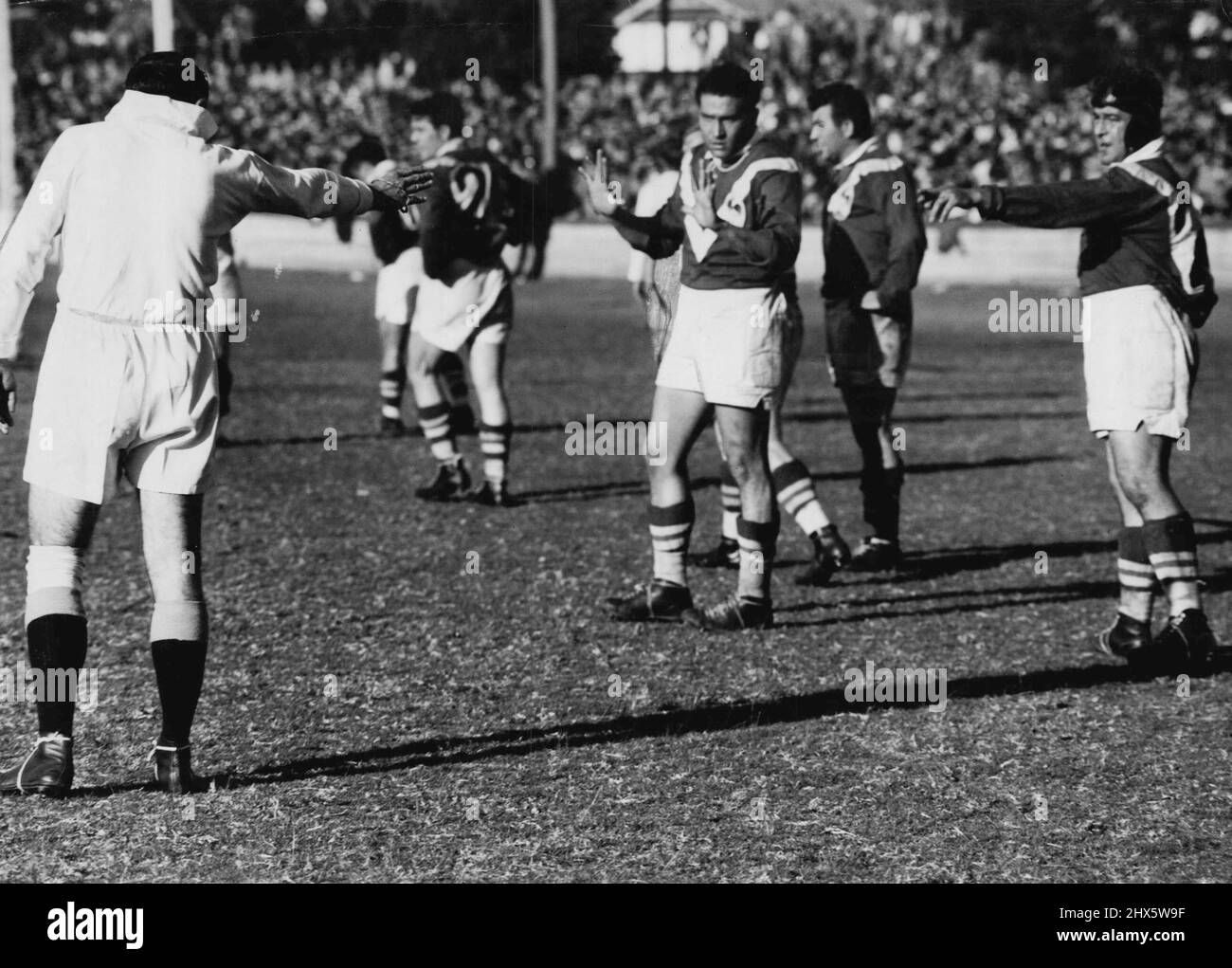 Schiedsrichter H. Gillard spricht in Gebärdensprache mit Männern der französischen Liga, während sie eine seiner vielen Entscheidungen gegen sie im gestrigen Spiel in Newcastle in Frage stellen. 27.Mai 1951. Stockfoto