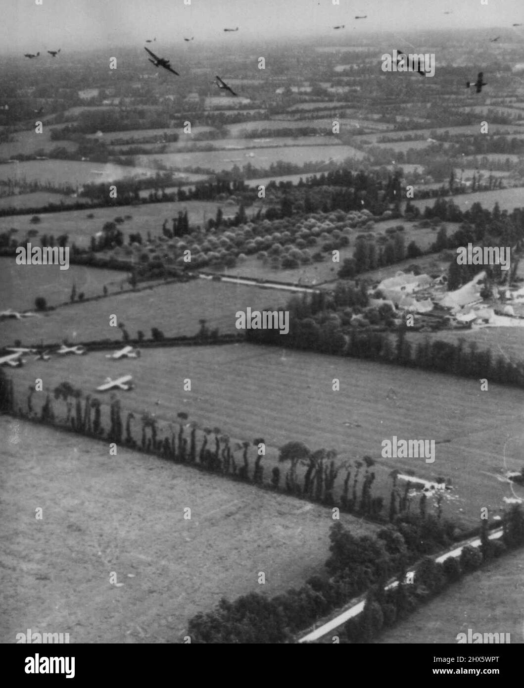US-Segelflugzeuge landen in der Normandie -- Hier ist ein Querschnitt der massiven Segelflugoperationen während der Invasion der Normandie, auf ein Ziel der US-Luftwaffe 9.. Segelflugzeuge und Schleppflugzeuge kreisen und viele Segelflugzeuge sind auf Feldern links und in mittlerer Entfernung gelandet. Beachte Smashed Glider unten rechts. 14. Juni 1944. (Foto von Associated Press Photo). Stockfoto