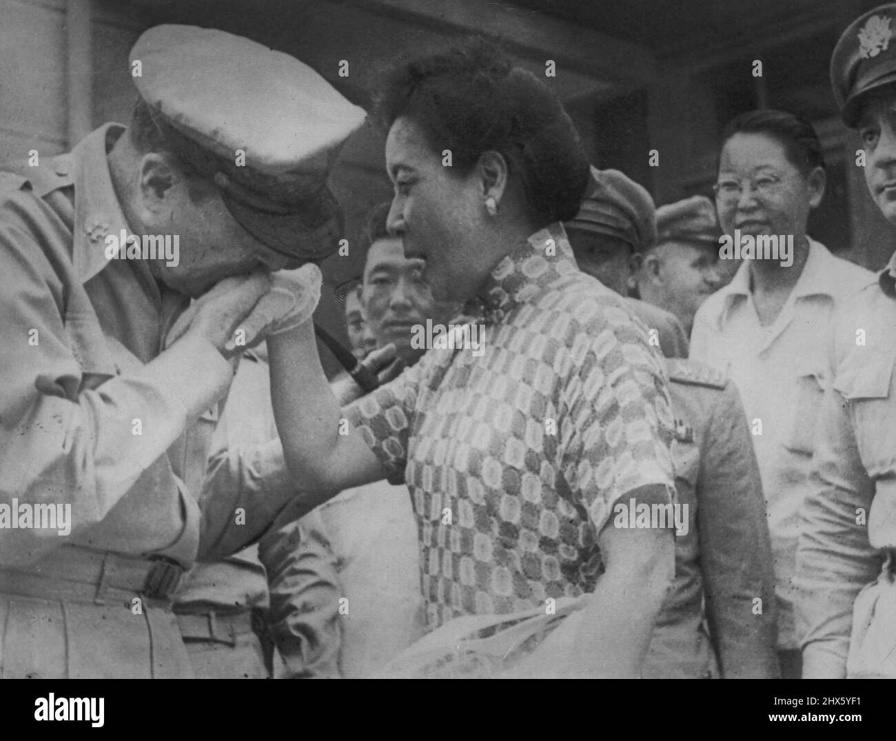 Ein Kuss für Madame Chiang-Gen. Douglas MacArthur küsst die mit weißen Handschuhen behafte Hand von Madme Chiang Kai Shek, kurz bevor der General nach einer Konferenz mit General Chiang Kai Shek und der nationalistischen Regierung von Taipei nach Formosa nach Tokio aufbrach ***** . 12. August 1950. (Foto von AP Wirephoto) ;Ein Kuss für Madame Chiang-Gen. Douglas MacArthur küsst die mit weißen Handschuhen bearbeitete Hand von Madme Chiang Kai Shek, kurz bevor der General nach einer Konferenz mit General Chiang aus Taipei nach Formosa nach Tokio aufbrach Stockfoto