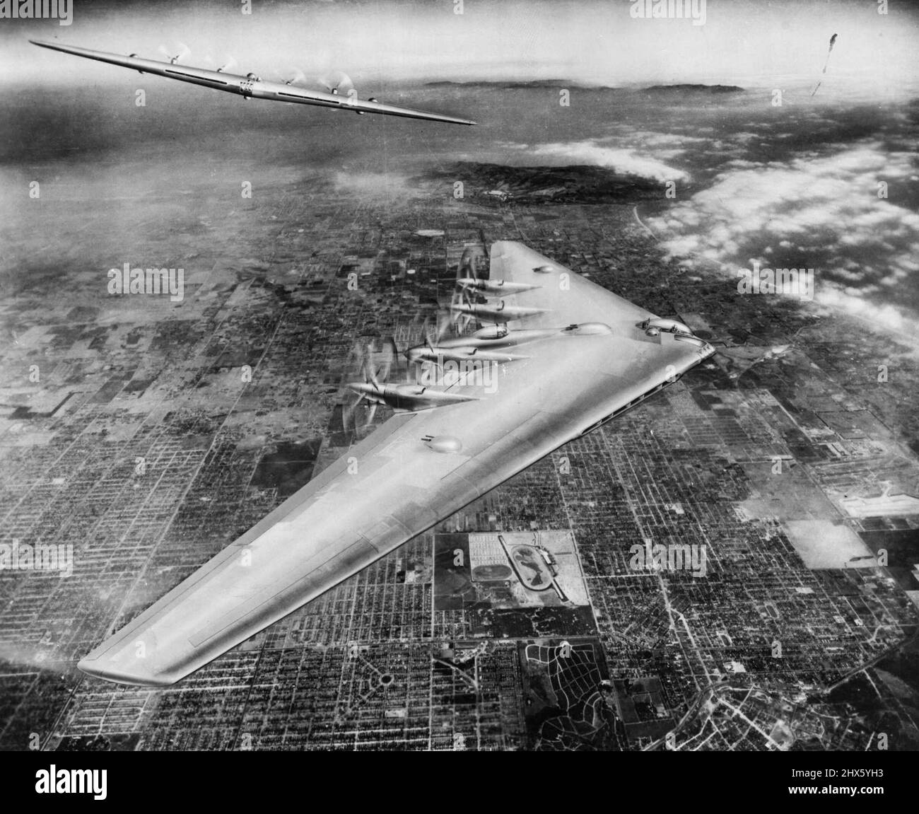 Hier ist eine künstlerische Konzeption des Northrop Flying Wing XB-35 im Flug über Los Angeles zu sehen. Oben auf dem Bild befindet sich südlich und direkt unter dem Flying Wing befindet sich die berühmte Hollywood Park Race Track. Northrop Field, Heimstadion des Northrop Flying Wing XB-35, befindet sich etwa in der Mitte des Bildes, das durch den Blick des Bombers blockiert wird. Die Vorderansicht des großen Bombers oben links zeigt, wie wenig Fläche das große Schiff der Luft im Flug präsentiert. 26.Mai 1947. ;Hier ist ein Künstler c Stockfoto