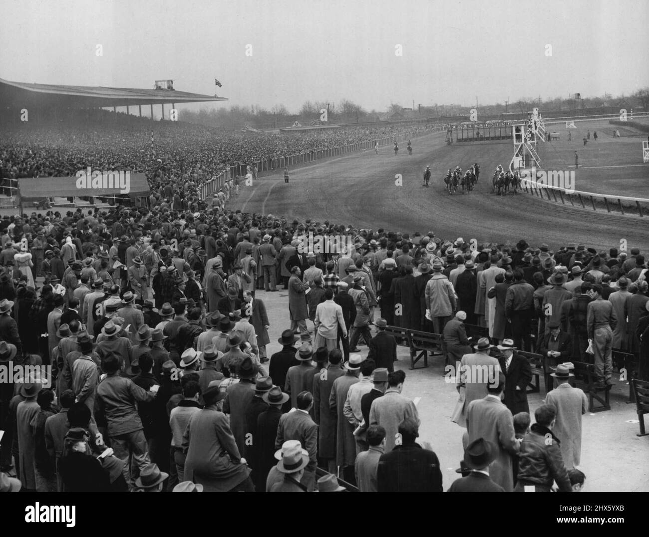 Racing Kehrt Nach New York Zurück -- Dies ist eine allgemeine Ansicht der Menge auf Jamaica Race Track in New York, April 1, als Pferde in der ersten Rennrunde die erste Kurve in einem Ereignis, das die Rückkehr des Tages Doppel auf New York Strecken nach einer Abwesenheit von vier Jahren markiert. Haile gewann das erste Rennen und Miss Degree das zweite Rennen. Das tägliche Doppelte zahlte $263,90 Dollar für 2 Dollar. 01. April 1949. (Foto von Associated Press Photo).;Racing kehrt nach New York zurück -- Dies ist eine allgemeine Ansicht der Menge auf der Jamaica Race Track Stockfoto