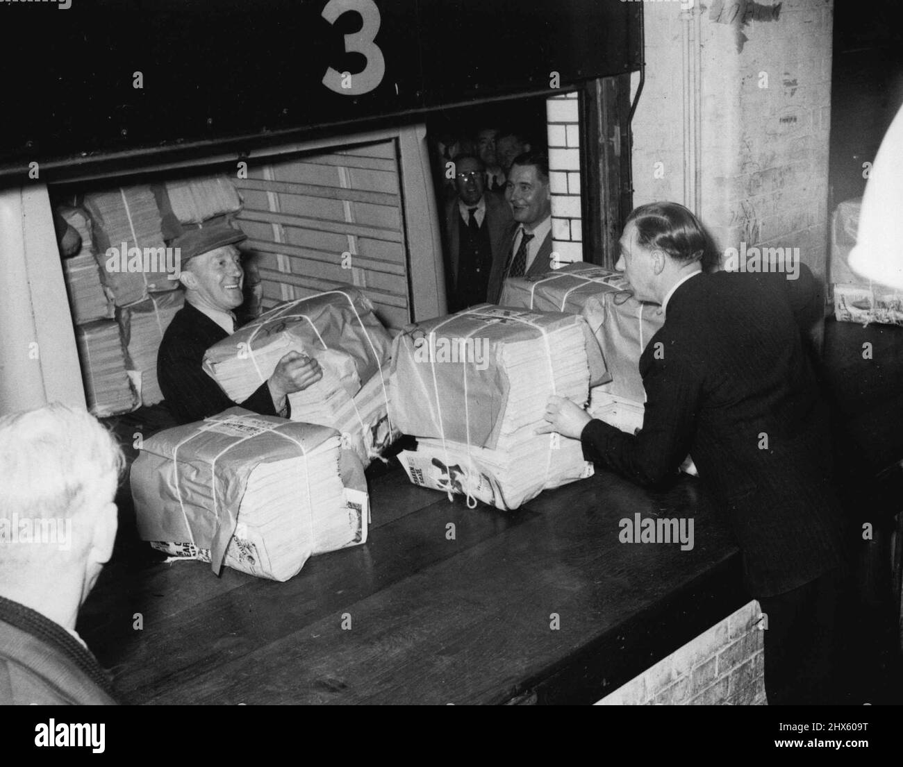 Stapel von Exemplaren des ersten seit März 25. veröffentlichten „tödlichen Spiegels“, die auf Lieferwagen vor den Büros der Zeitung in der Fetter-Lane verladen werden. Nach einem fast vierwöchigen Streik nahmen Großbritanniens nationale Zeitungen heute die Veröffentlichung wieder auf (21-4-55). Der Verband der Zeitungseigentümer erzielte am Dienstagabend eine Einigung mit der Amalgamated Engineering Union und der Electrical Trades Union, nachdem die Gespräche den ganzen Tag über andauerten. 21. April 1955. (Foto von Daily Mirror). ;copi-Pakete Stockfoto